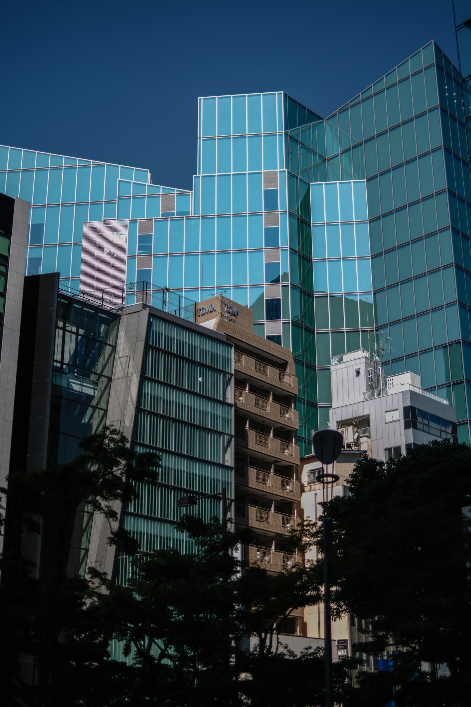 城市風景，交錯的藍色玻璃建築和周圍結構