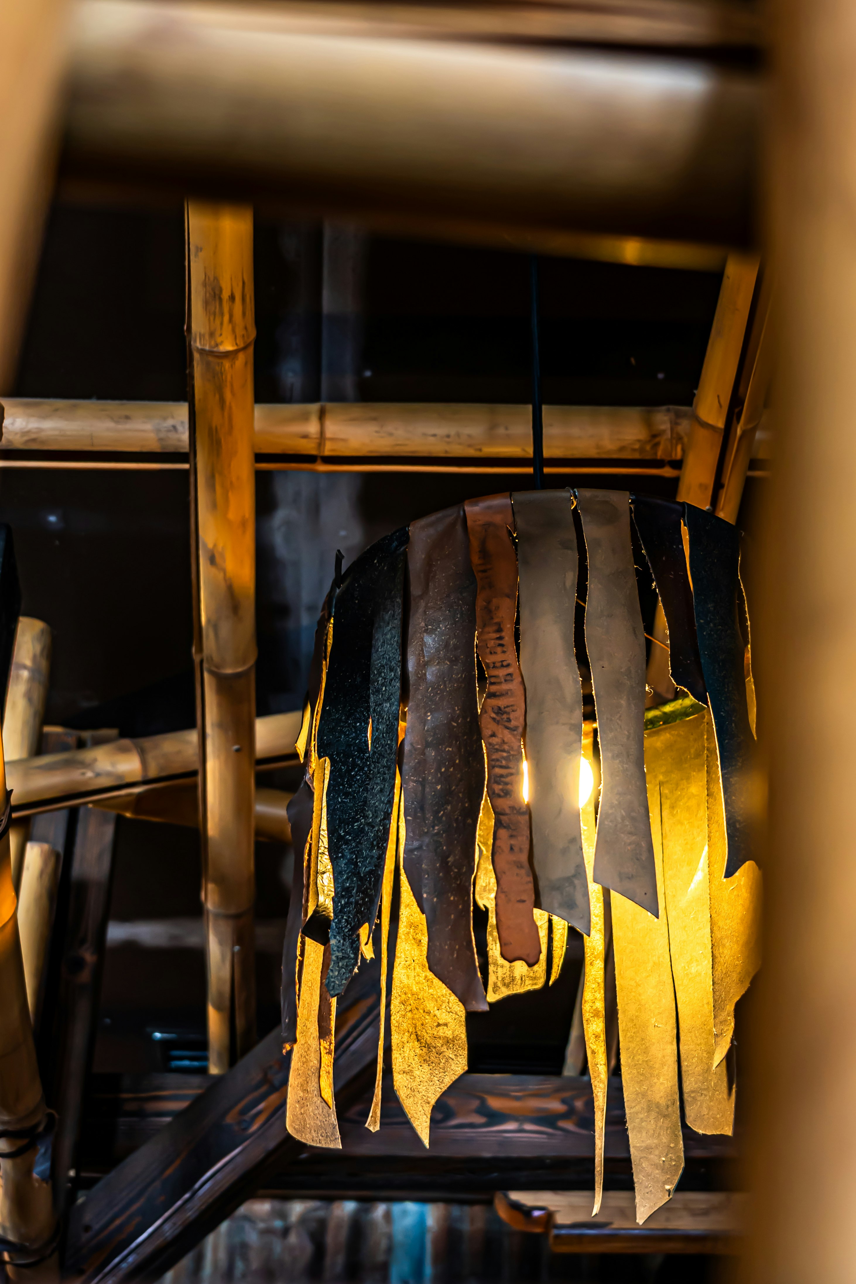 Kobe back-alley lanterns and leather goods hanging from a wooden shelf