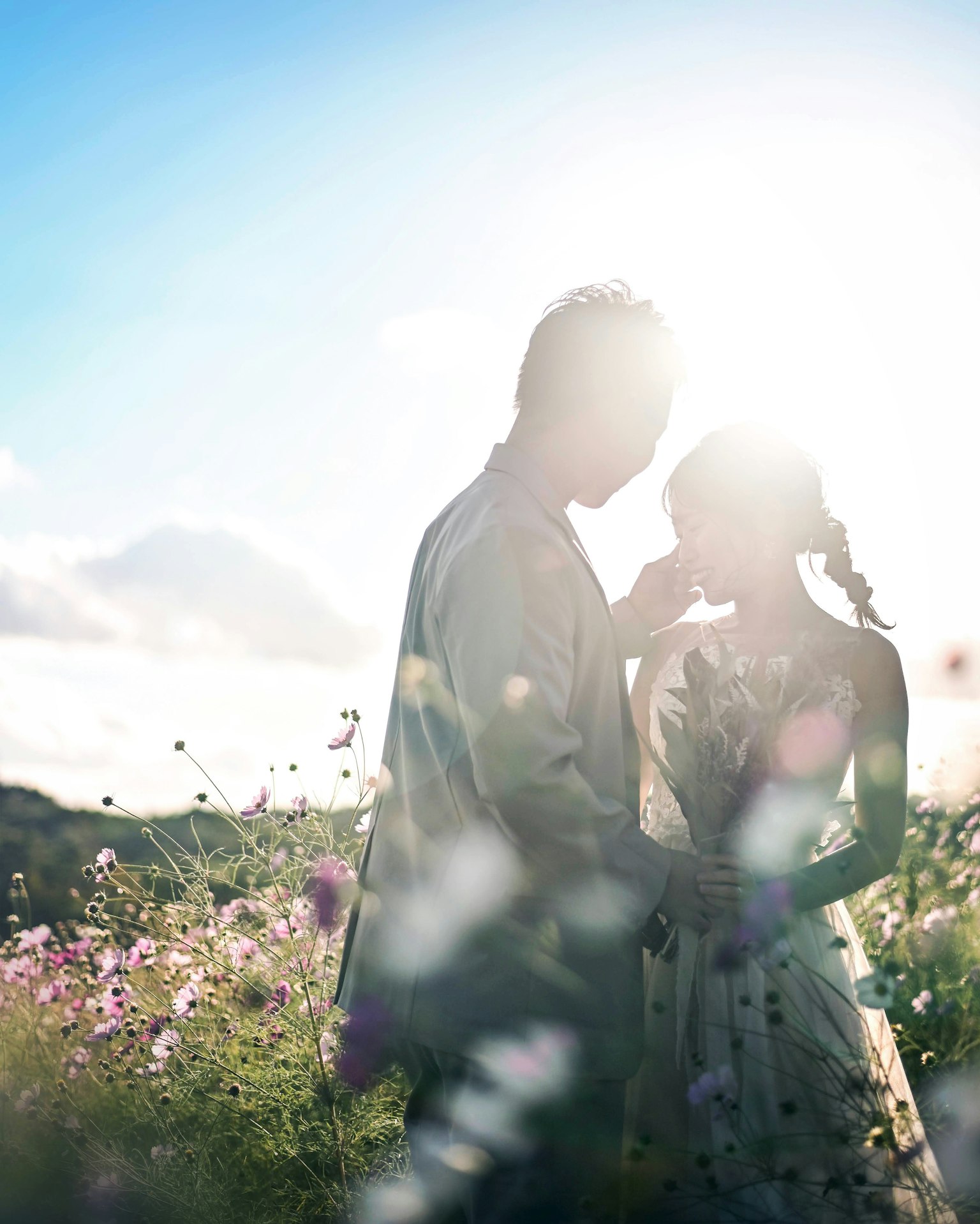 Silhouette of a couple in a flower field bathed in beautiful light capturing a romantic moment