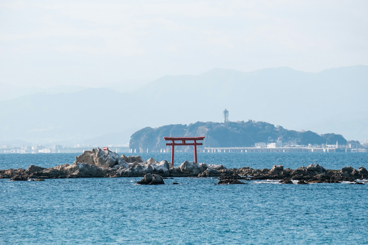 Torii près de la mer avec une île en arrière-plan