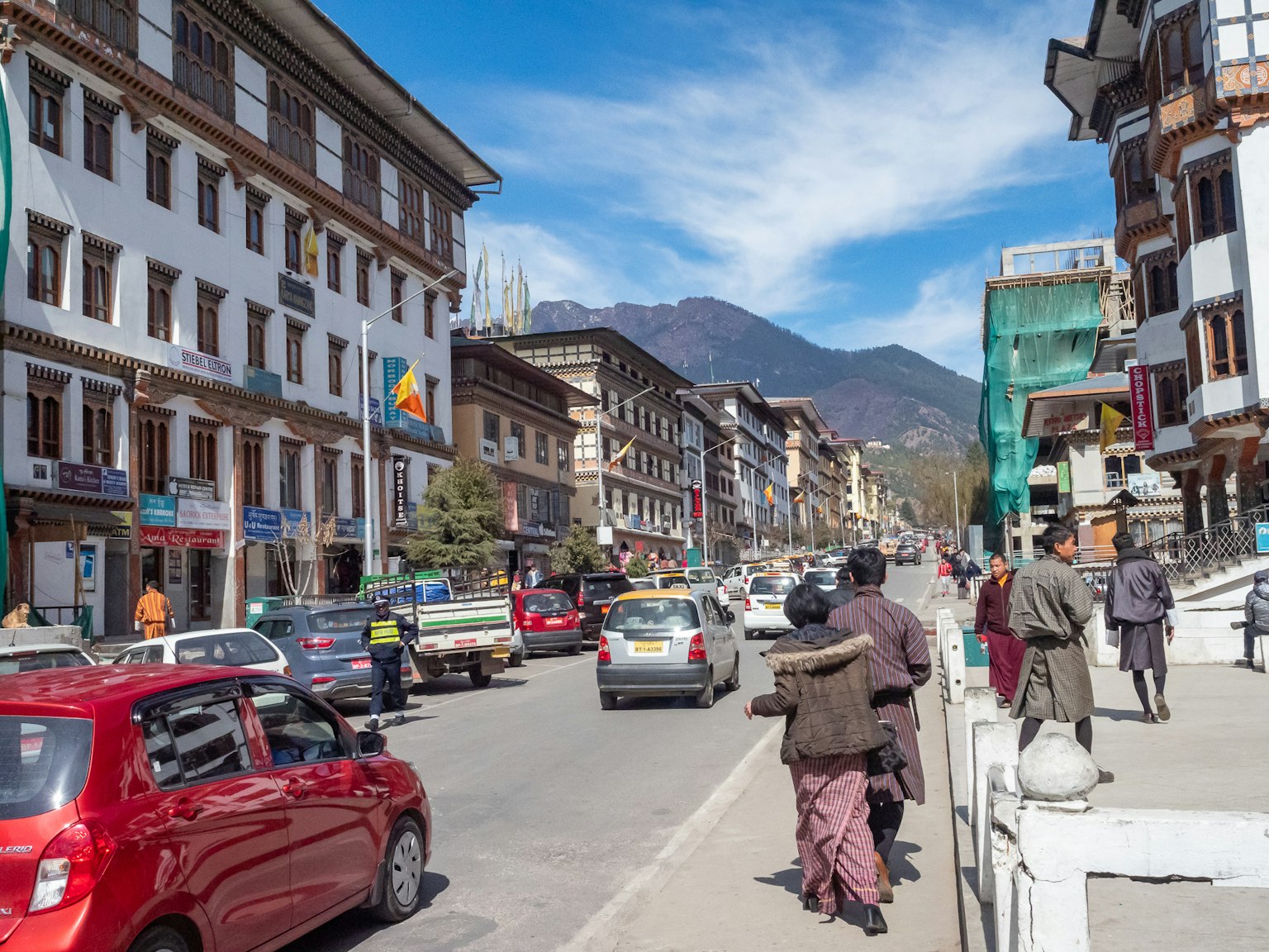 Scène de rue à Thimphou au Bhoutan avec des gens marchant et des voitures garées