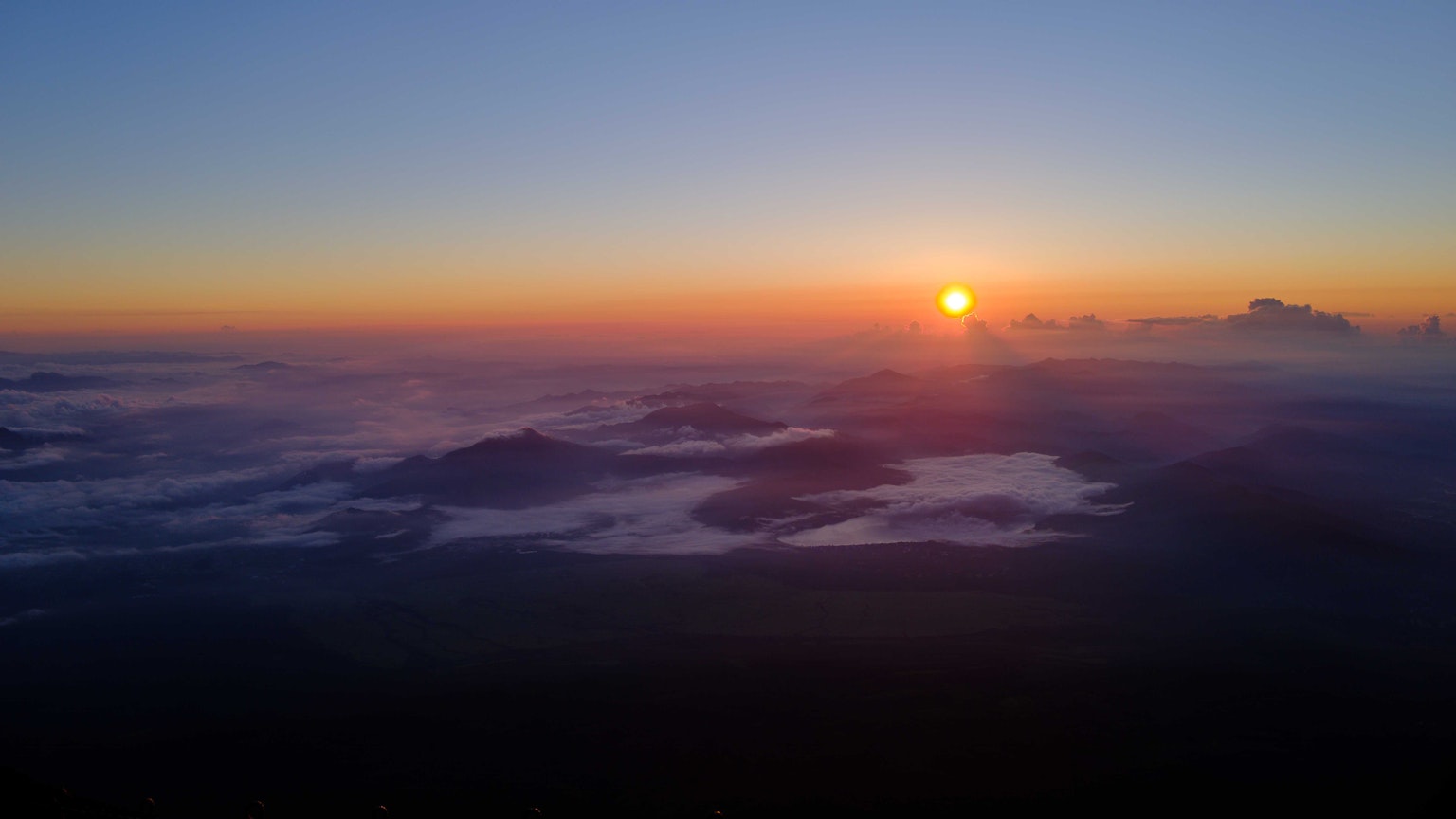 Stupendo tramonto sopra le nuvole con montagne in lontananza