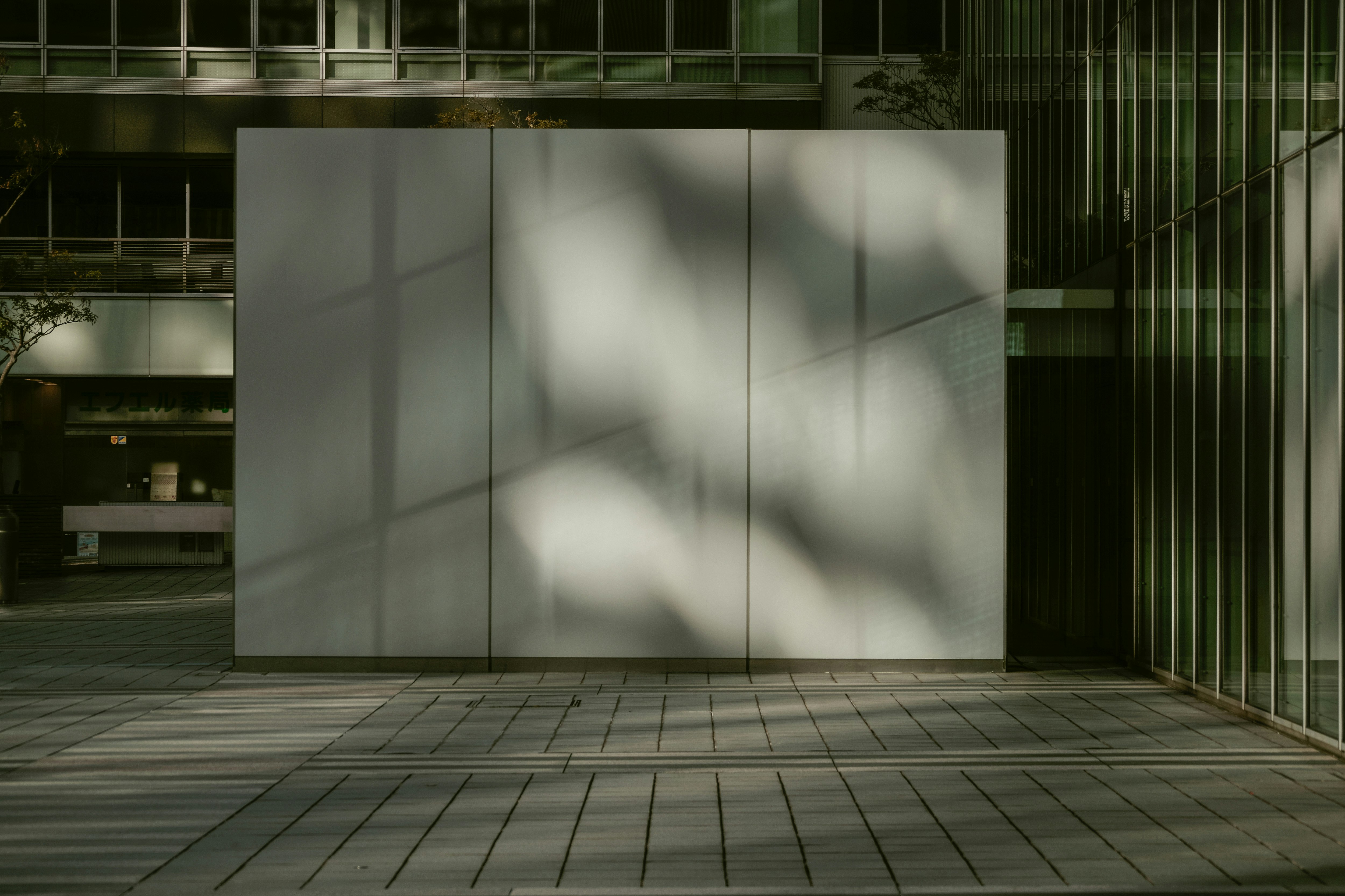 passage urbain avec un grand panneau abstrait sur la façade d’un bâtiment