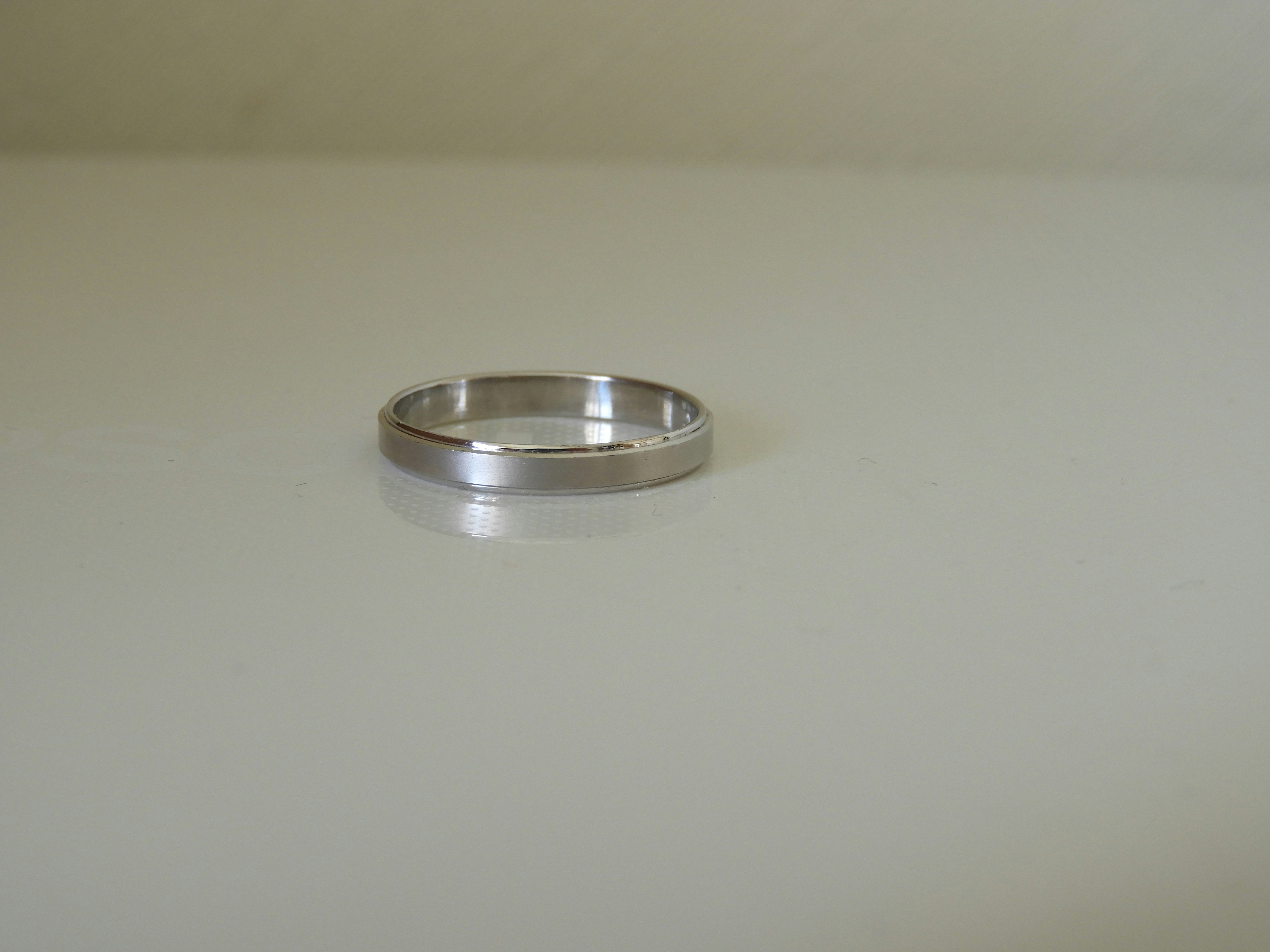 A metal ring placed on a white surface, still life