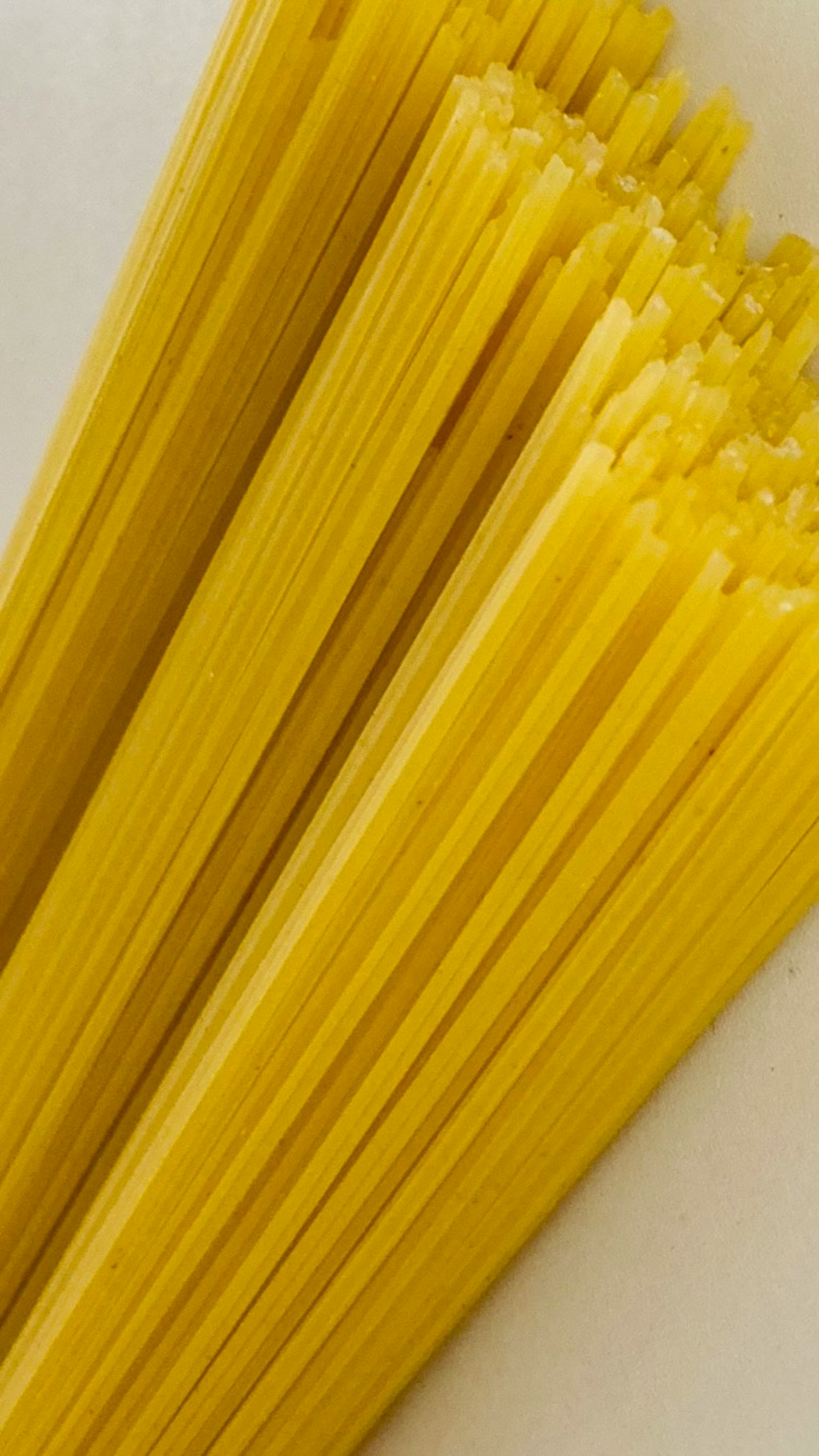 Un paquet de spaghettis jaunes posé sur un fond blanc