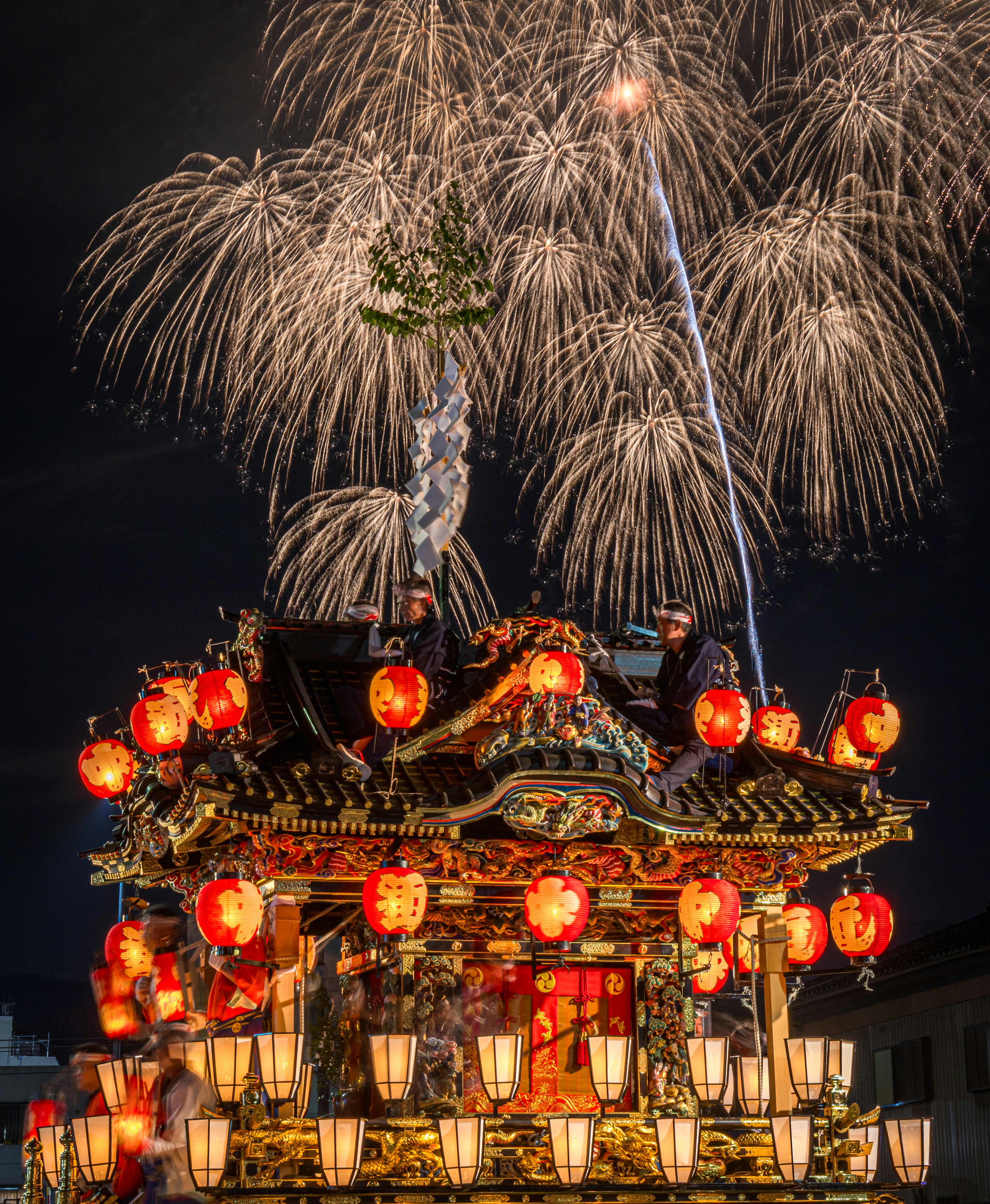 提灯と花火が彩る屋台の祭りの夜景