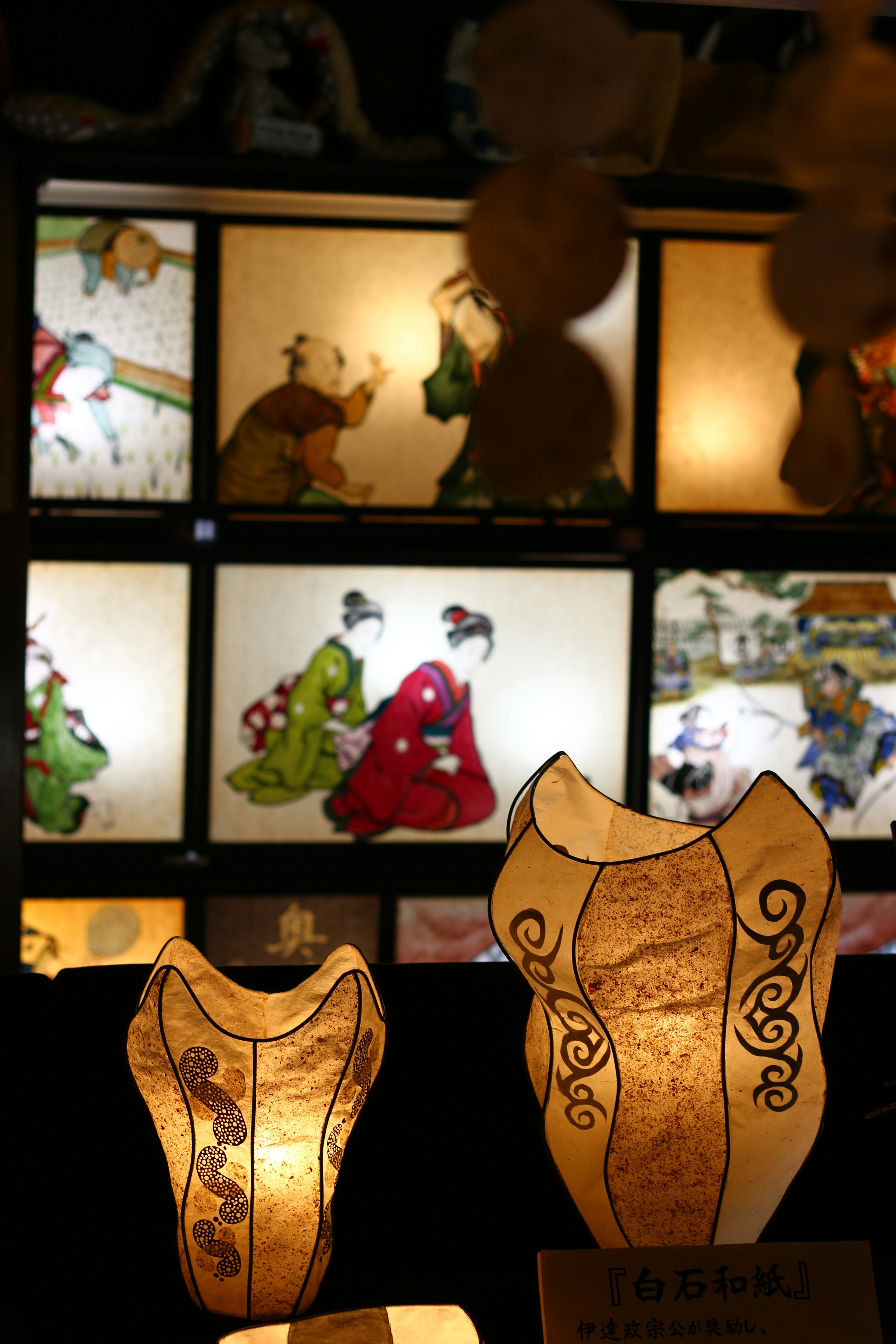 白石和紙の和紙人形が並ぶ展示棚の画像