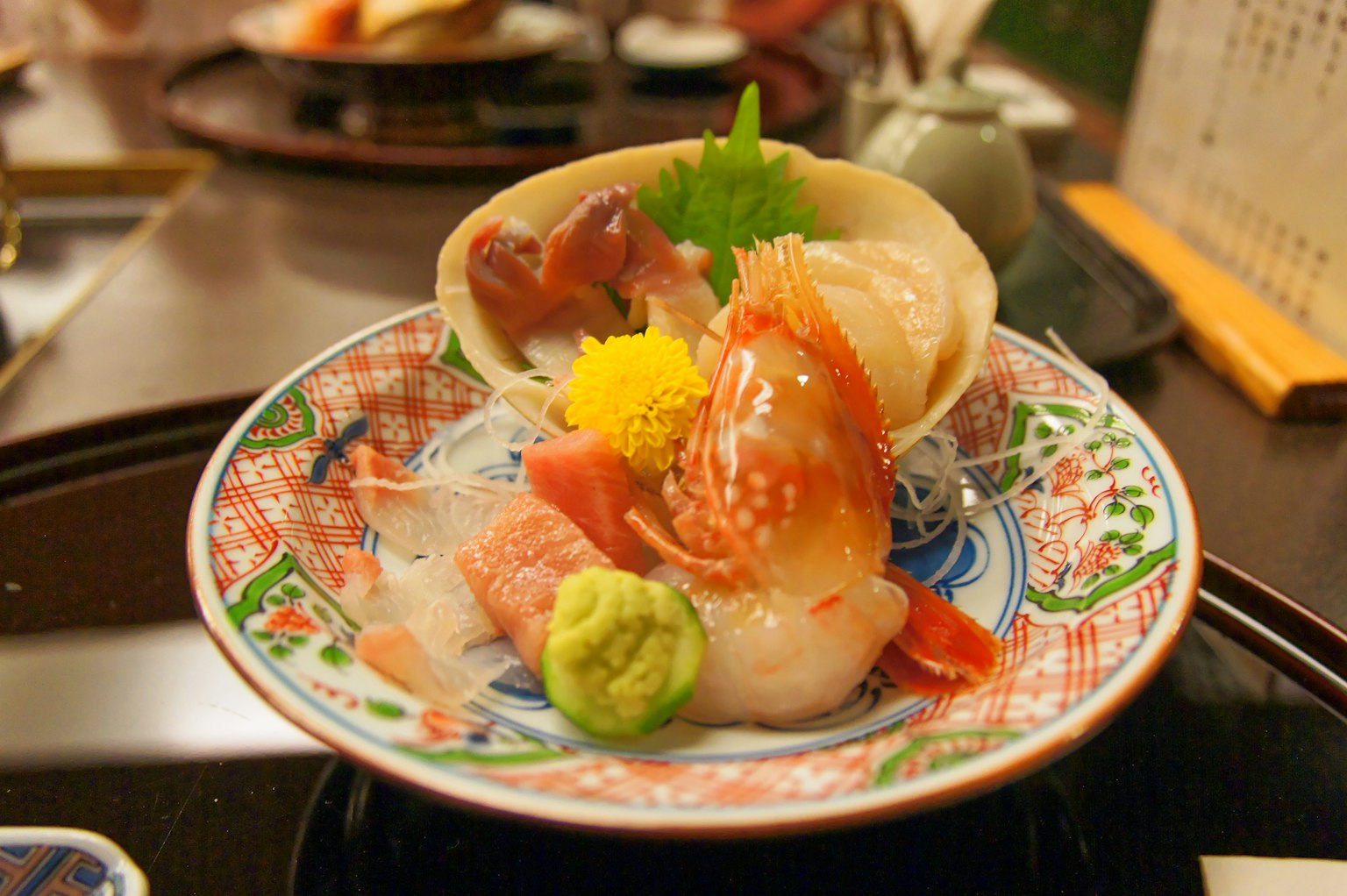 Beautifully arranged sashimi plate featuring fresh shrimp and scallops with shredded daikon and wasabi