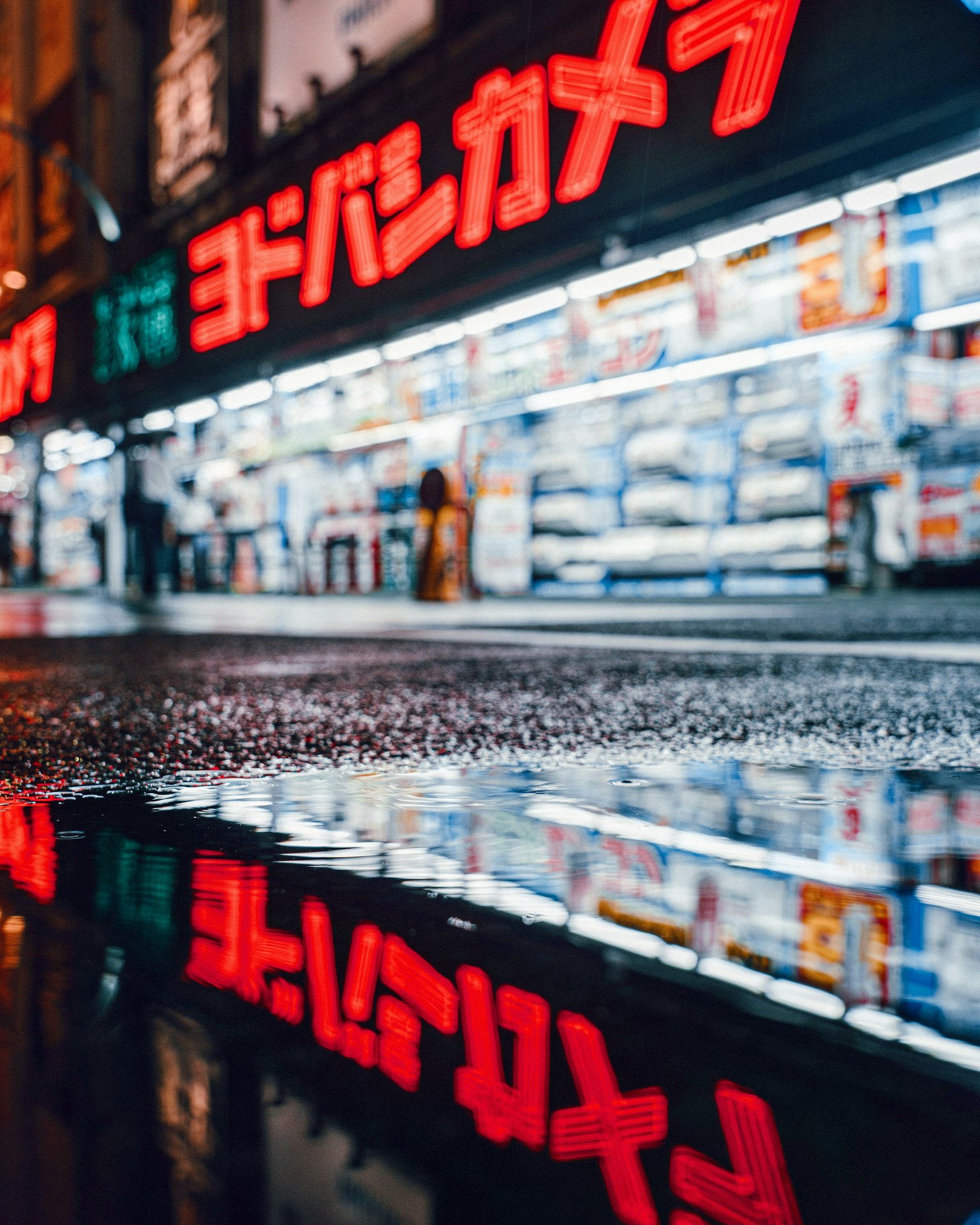濕滑人行道上反射的彩色霓虹燈和商店展示