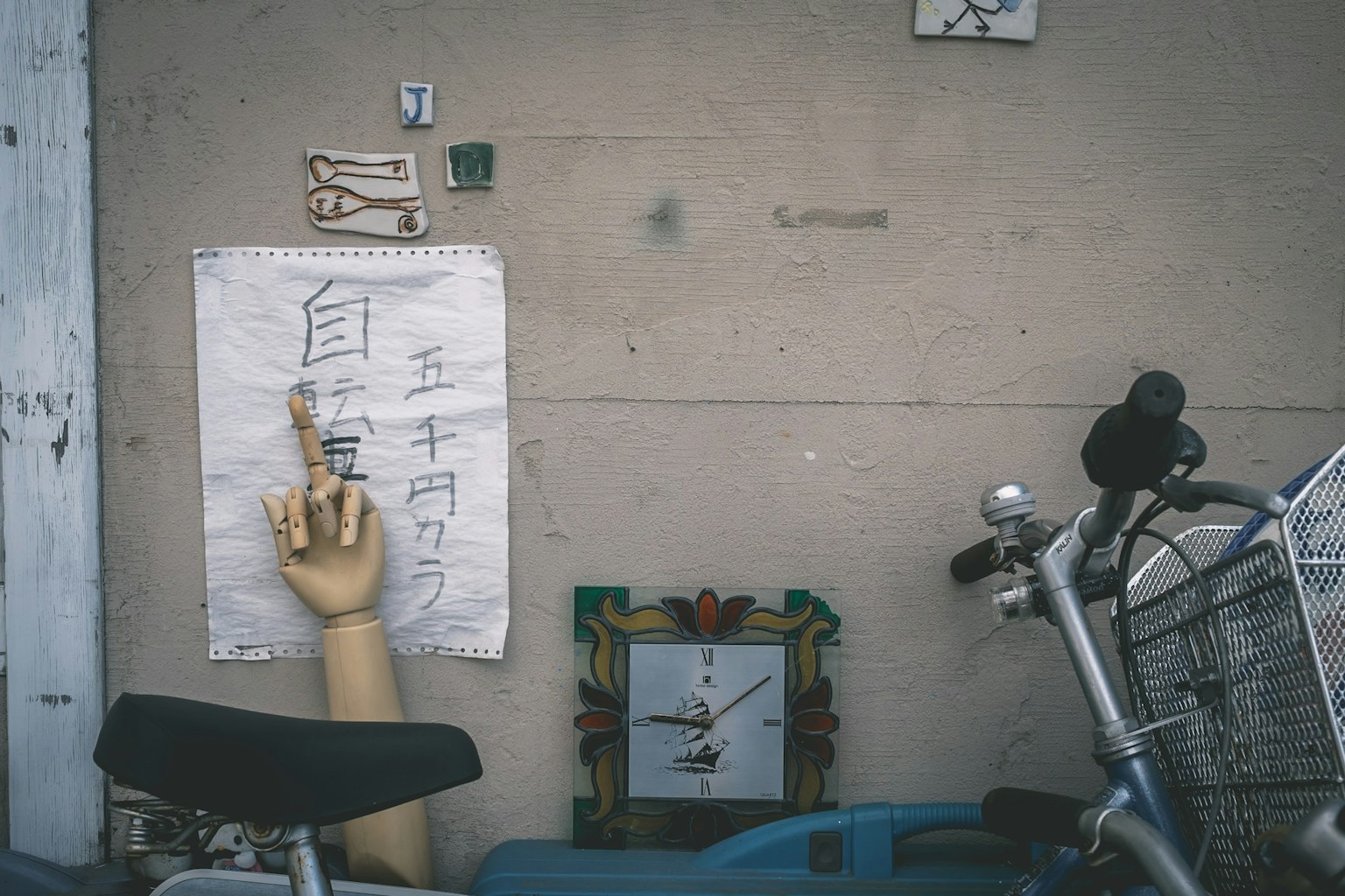 Un papier écrit sur un mur et un modèle de main à côté d'un vélo et d'une horloge