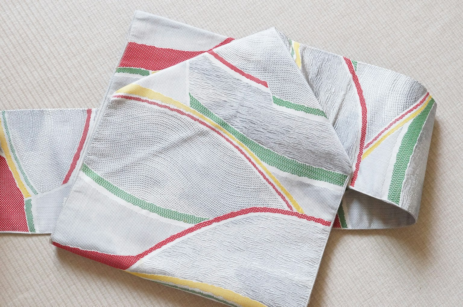 Tissu blanc avec des lignes abstraites colorées en rouge vert et jaune