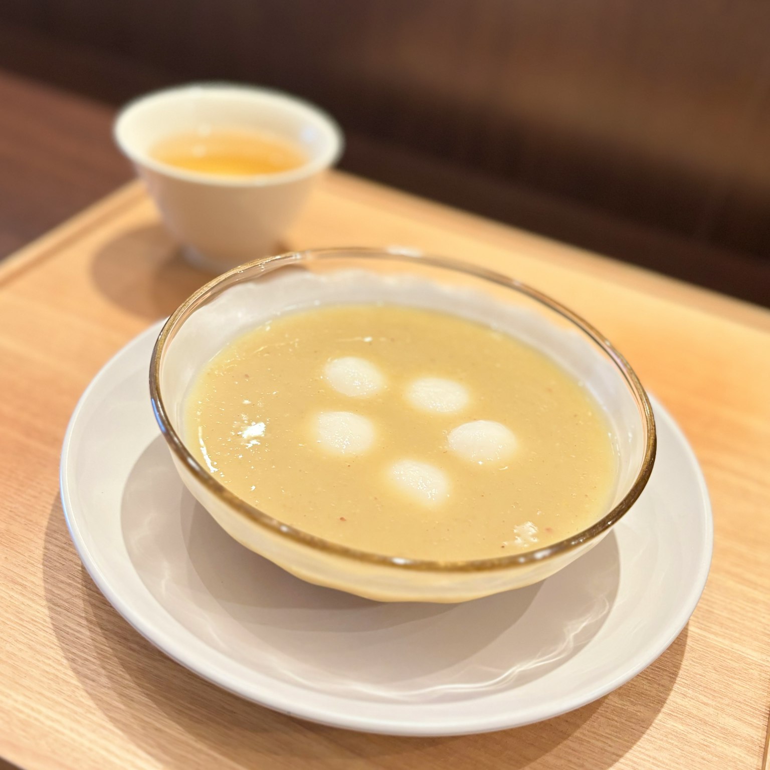 碗中盛著熱湯和白色餃子，旁邊有一杯茶