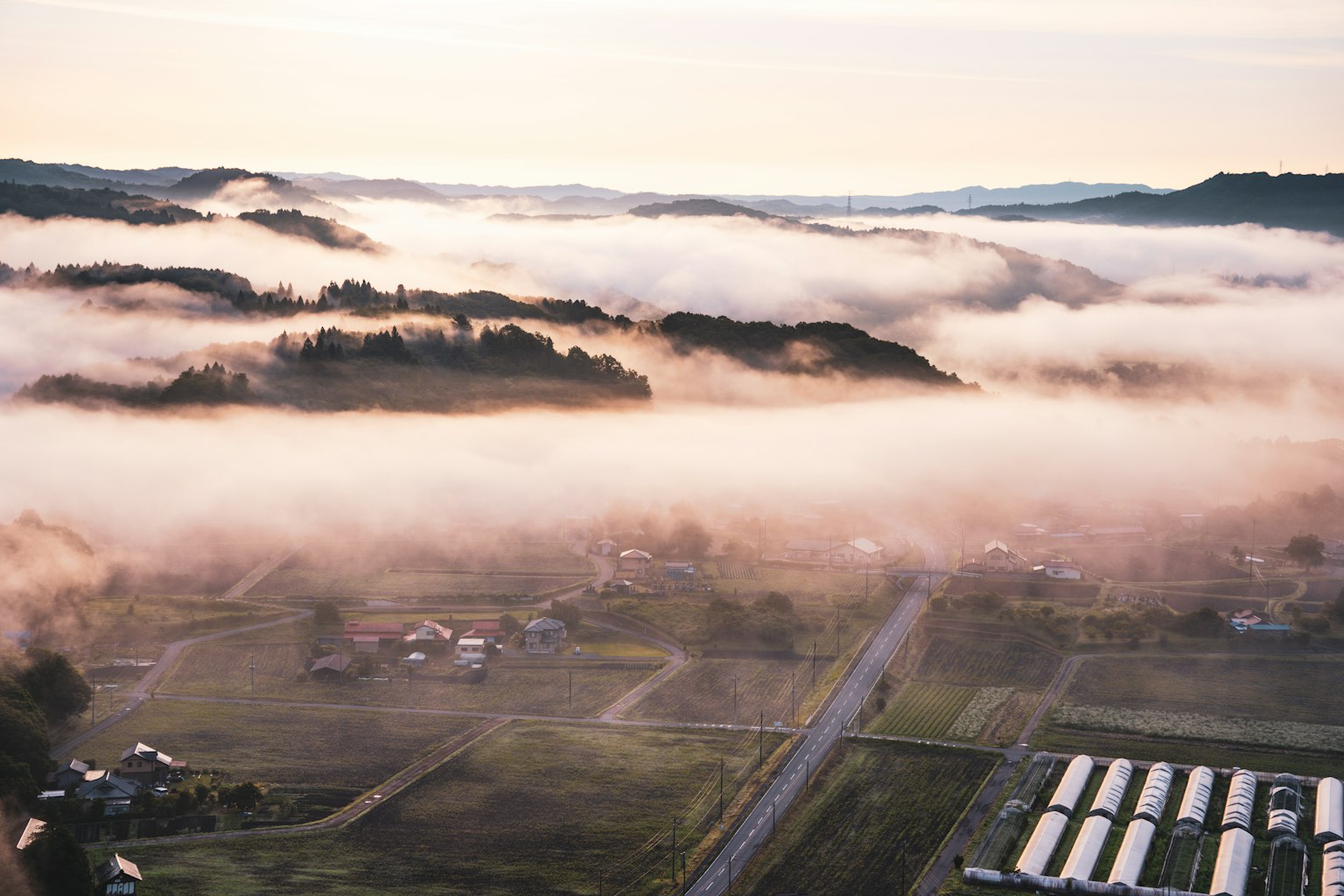 Vista aerea di un paesaggio rurale nebbioso con colline ondulate