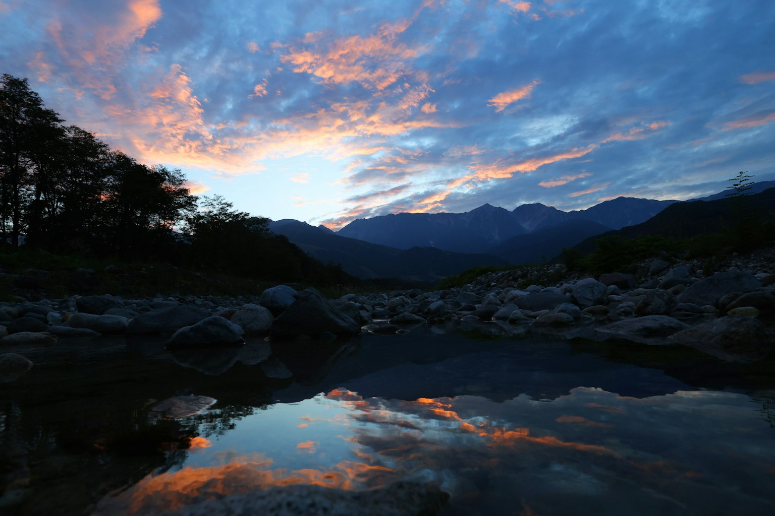 风景如画的河流景观，夕阳倒影与群山