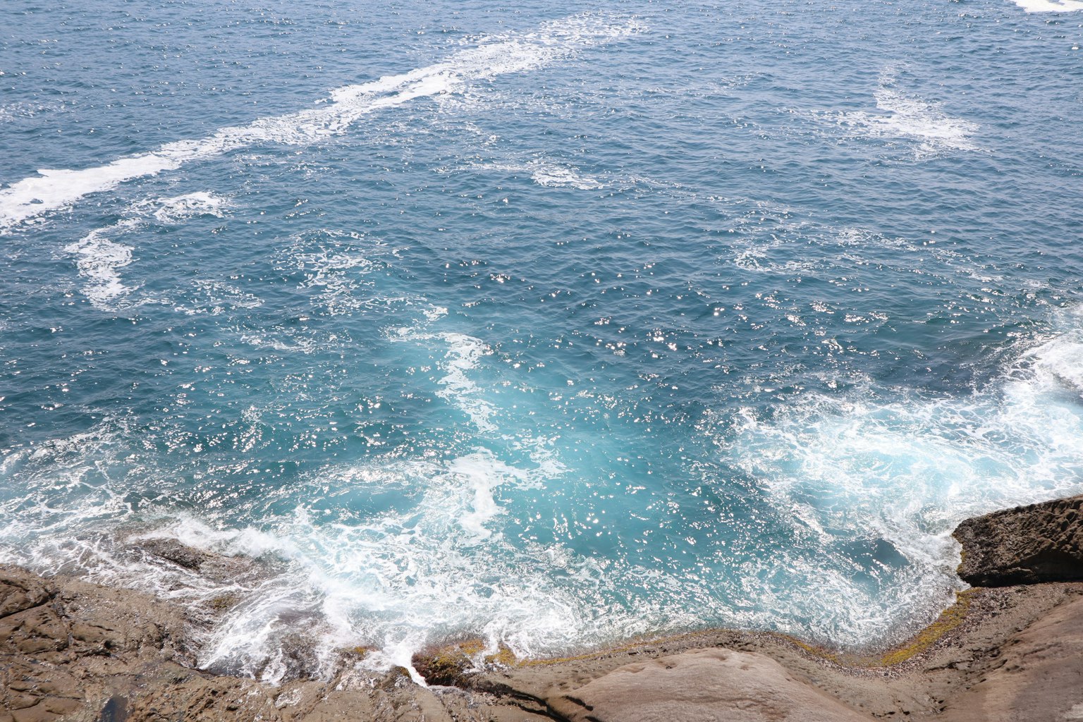 Onde oceaniche blu e costa rocciosa