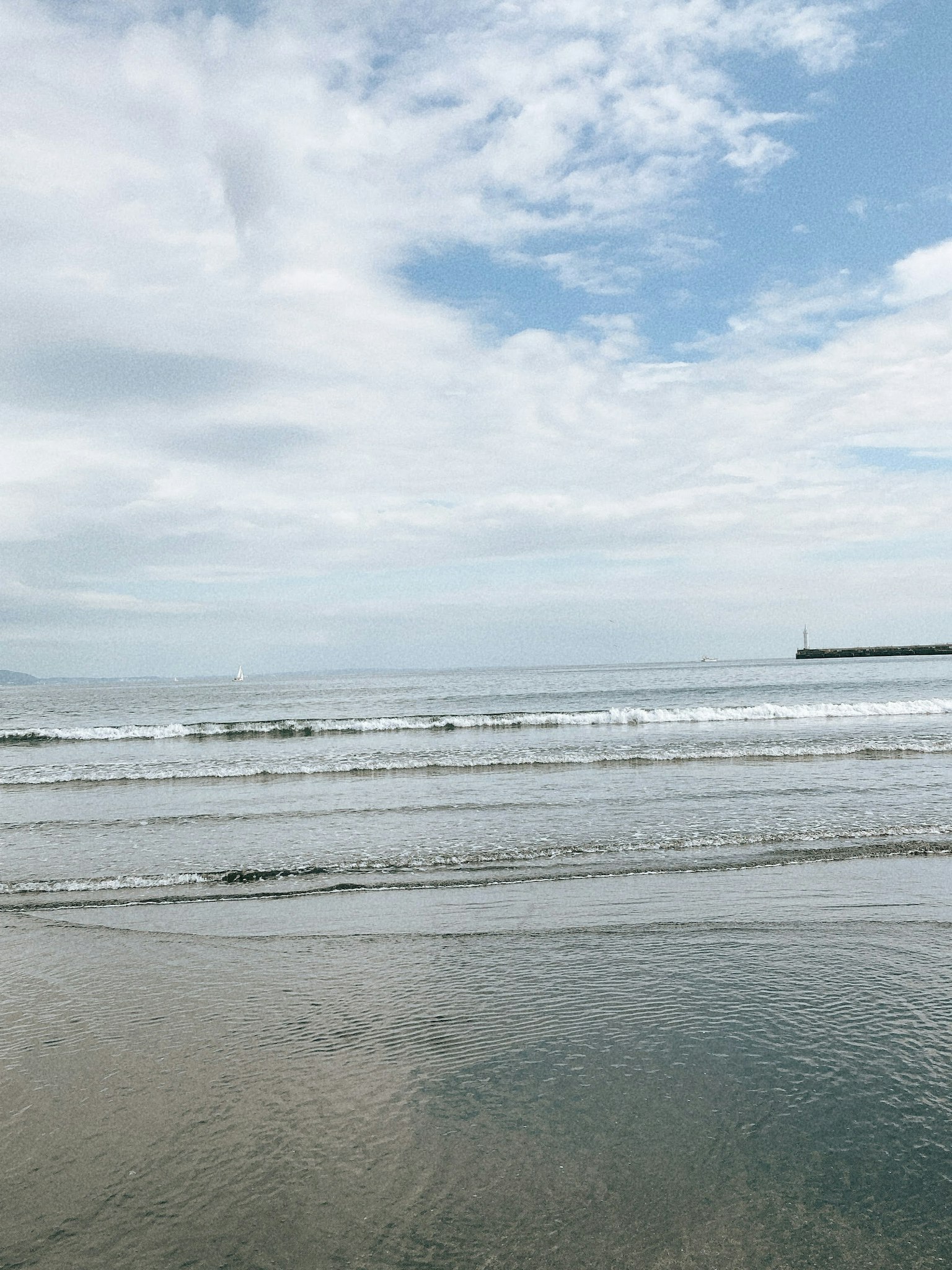 Serene beach view with blue sky and gentle waves