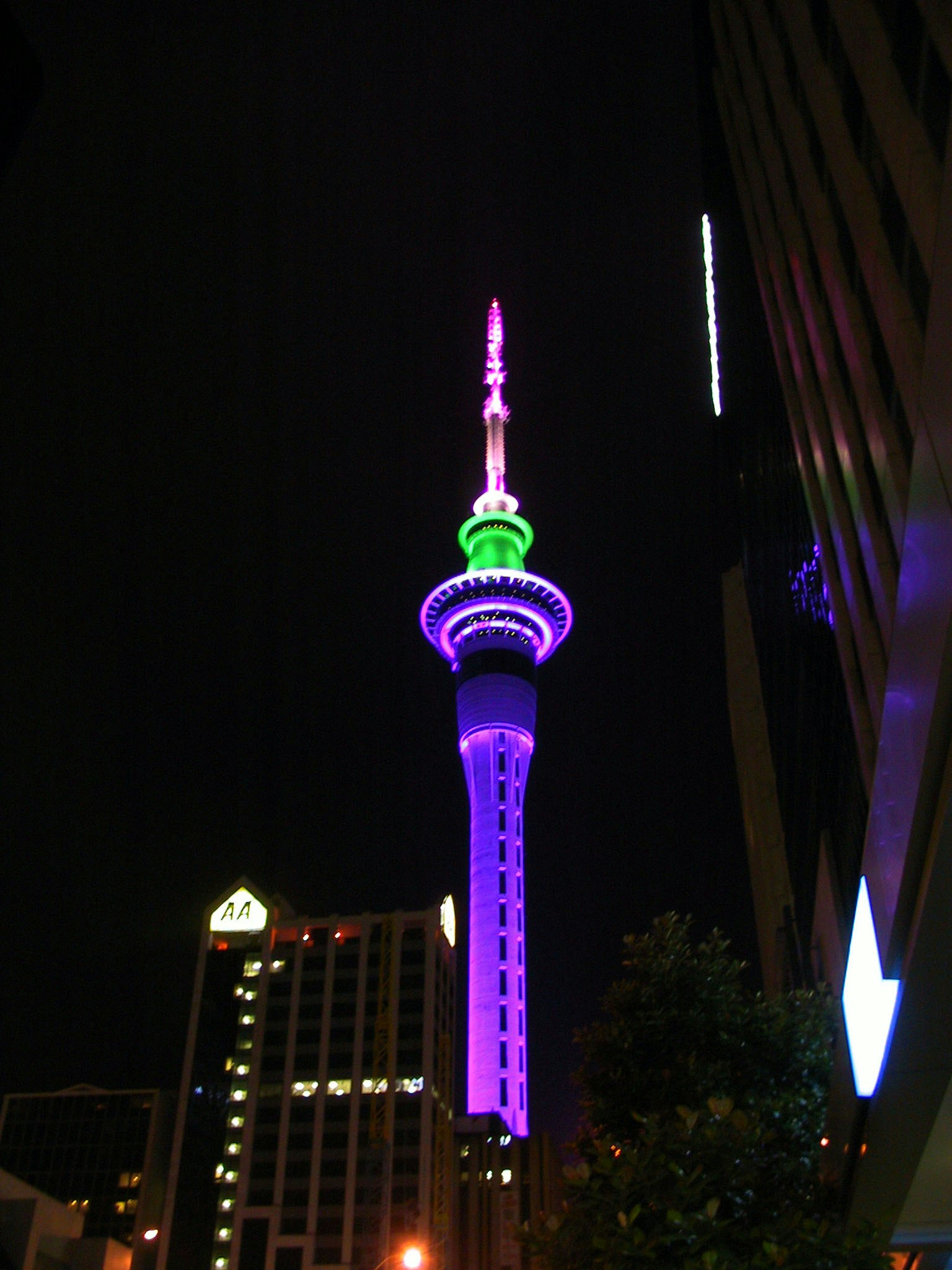 Sky Tower nachts beleuchtet mit lila und grünen Lichtern