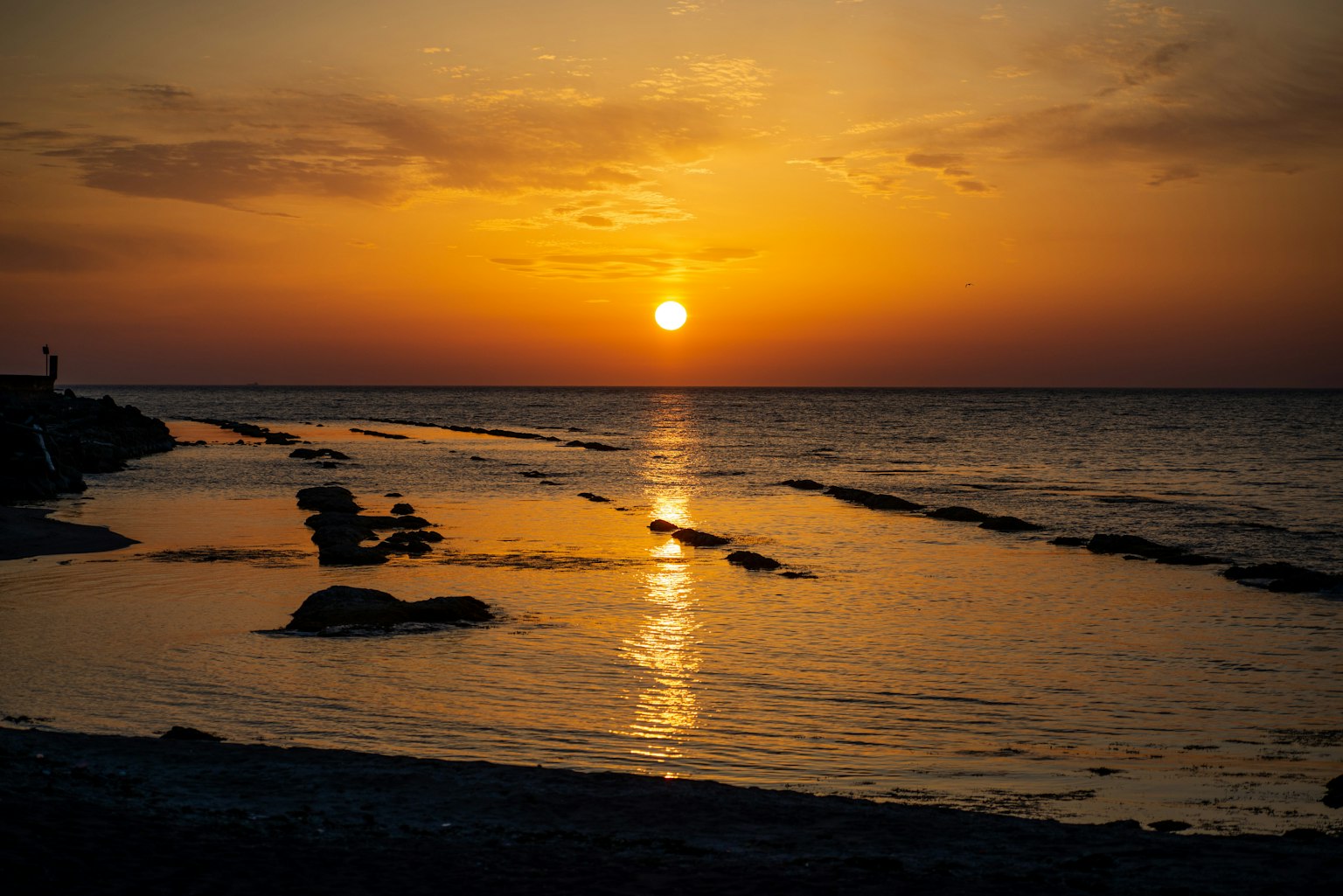 Beautiful sunset over the ocean with waves reflecting