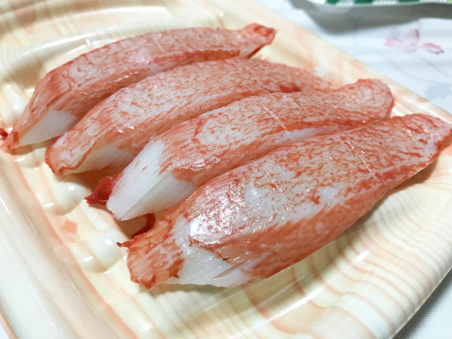 Sliced sushi with vibrant red fish on a wooden plate