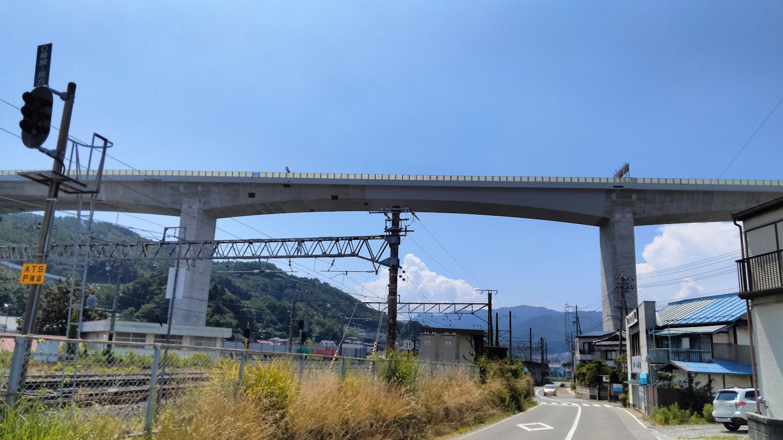 Escena de puente elevado y ferrocarril bajo un cielo azul