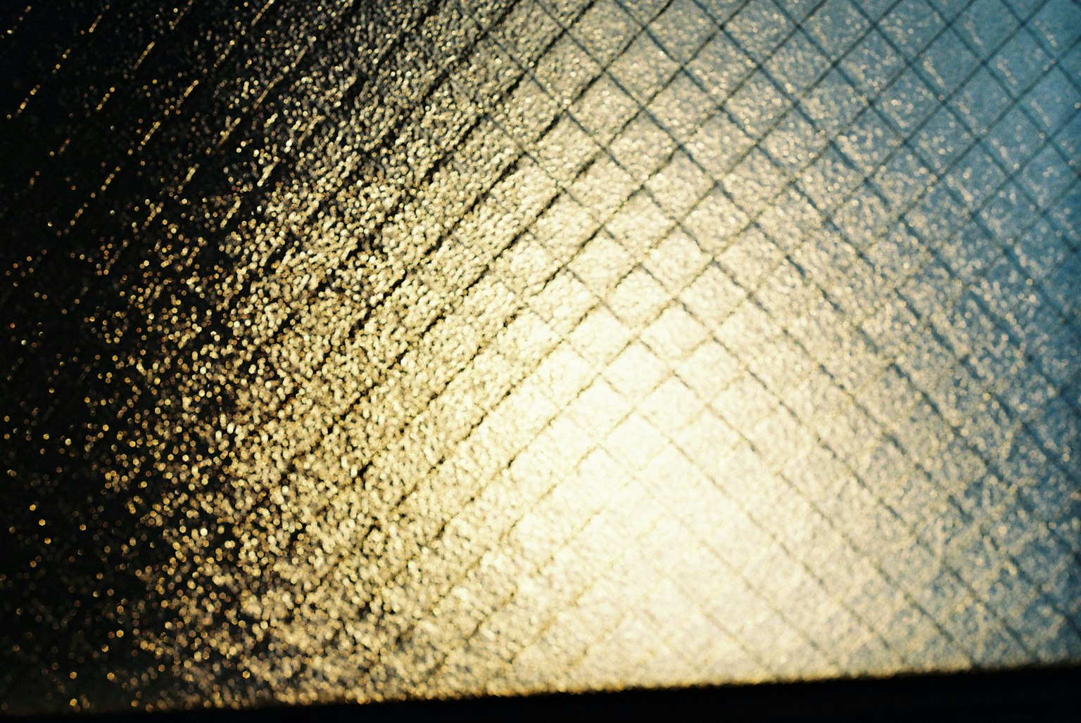 Textured glass with a diamond pattern reflecting light