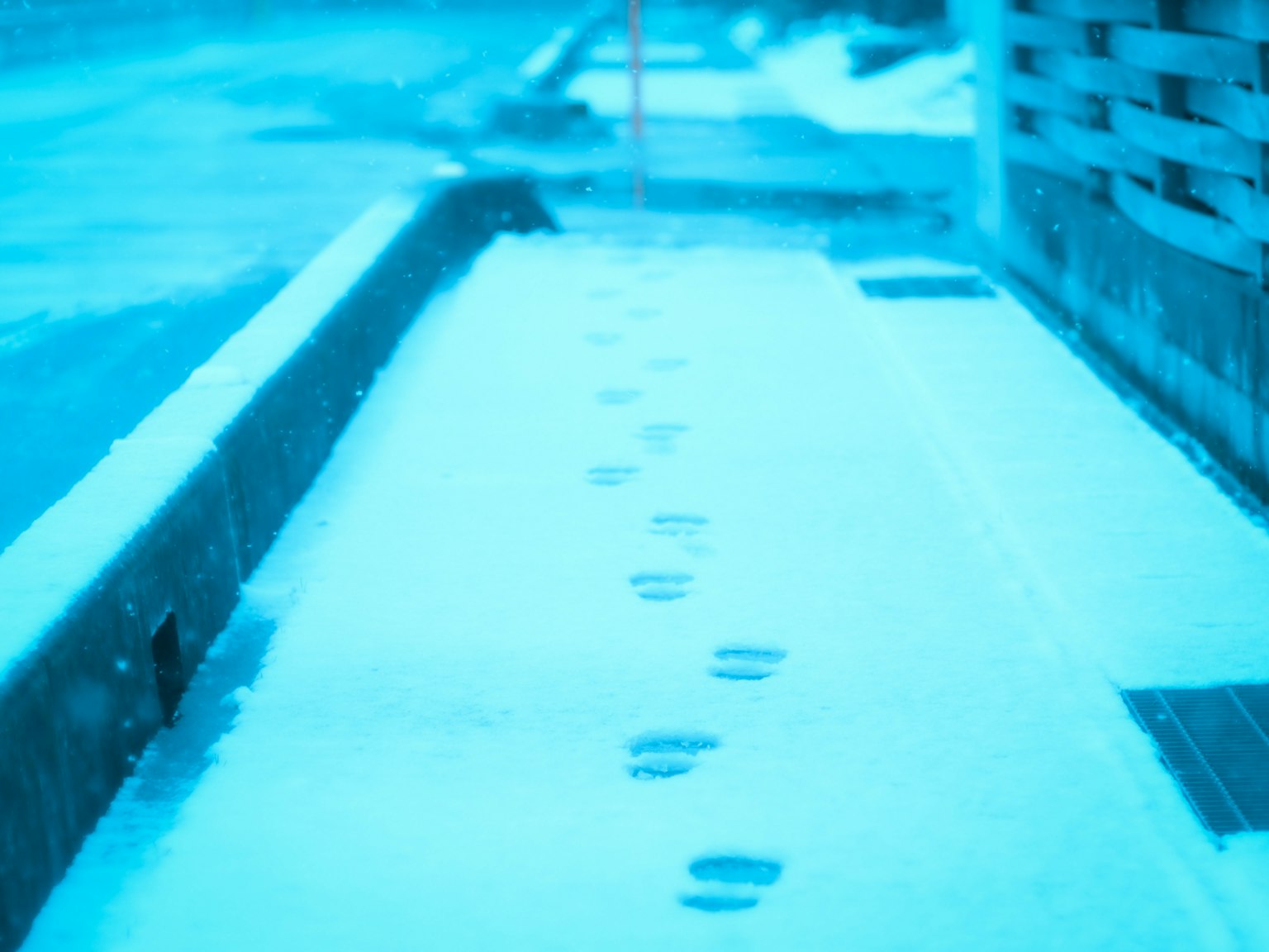 Des empreintes dans la neige sur un trottoir calme
