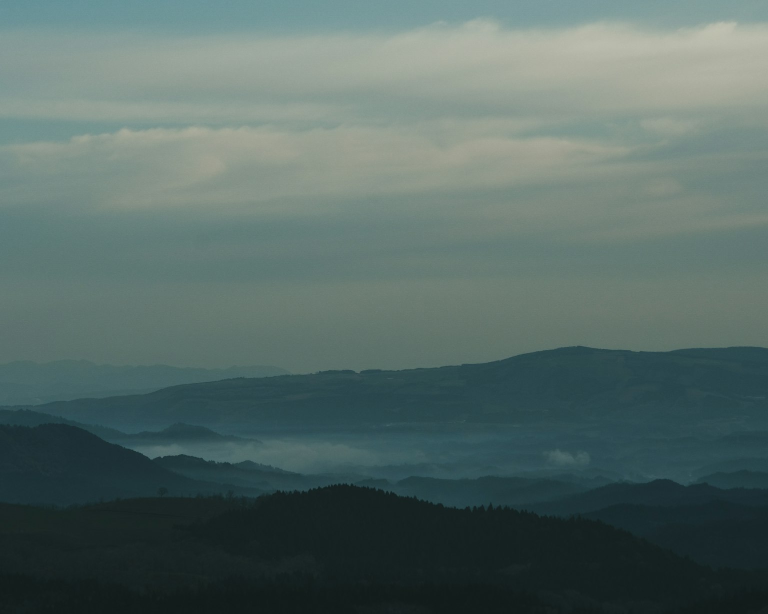 Vista distante di montagne sotto un cielo blu con nuvole