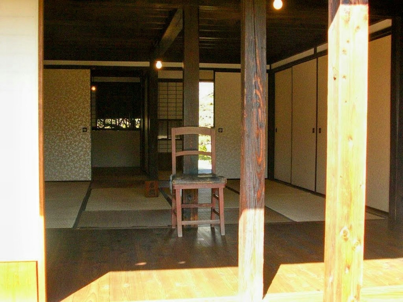 传统日本房屋的内部视图，中央有一把木椅