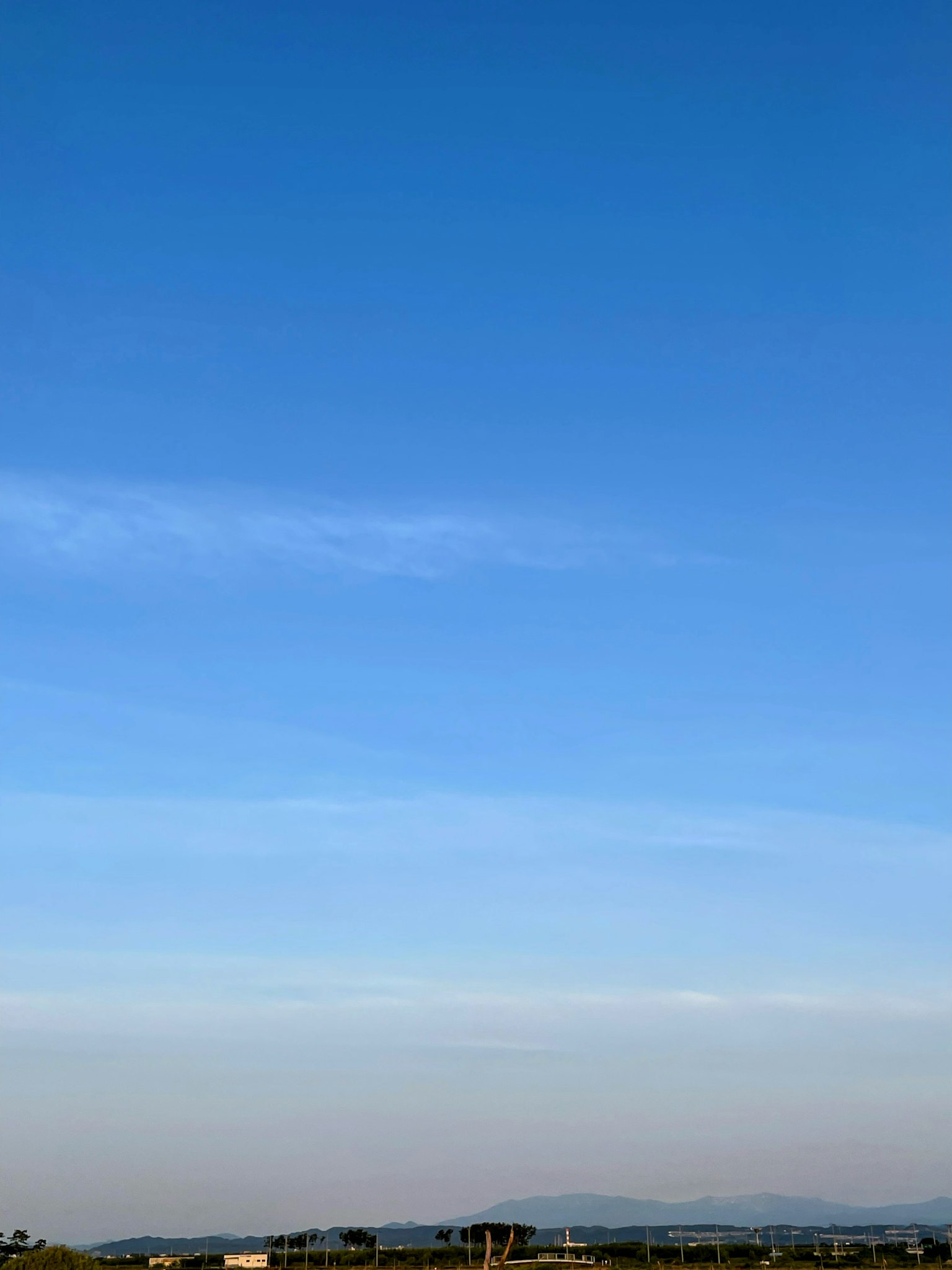 A clear blue sky with soft clouds