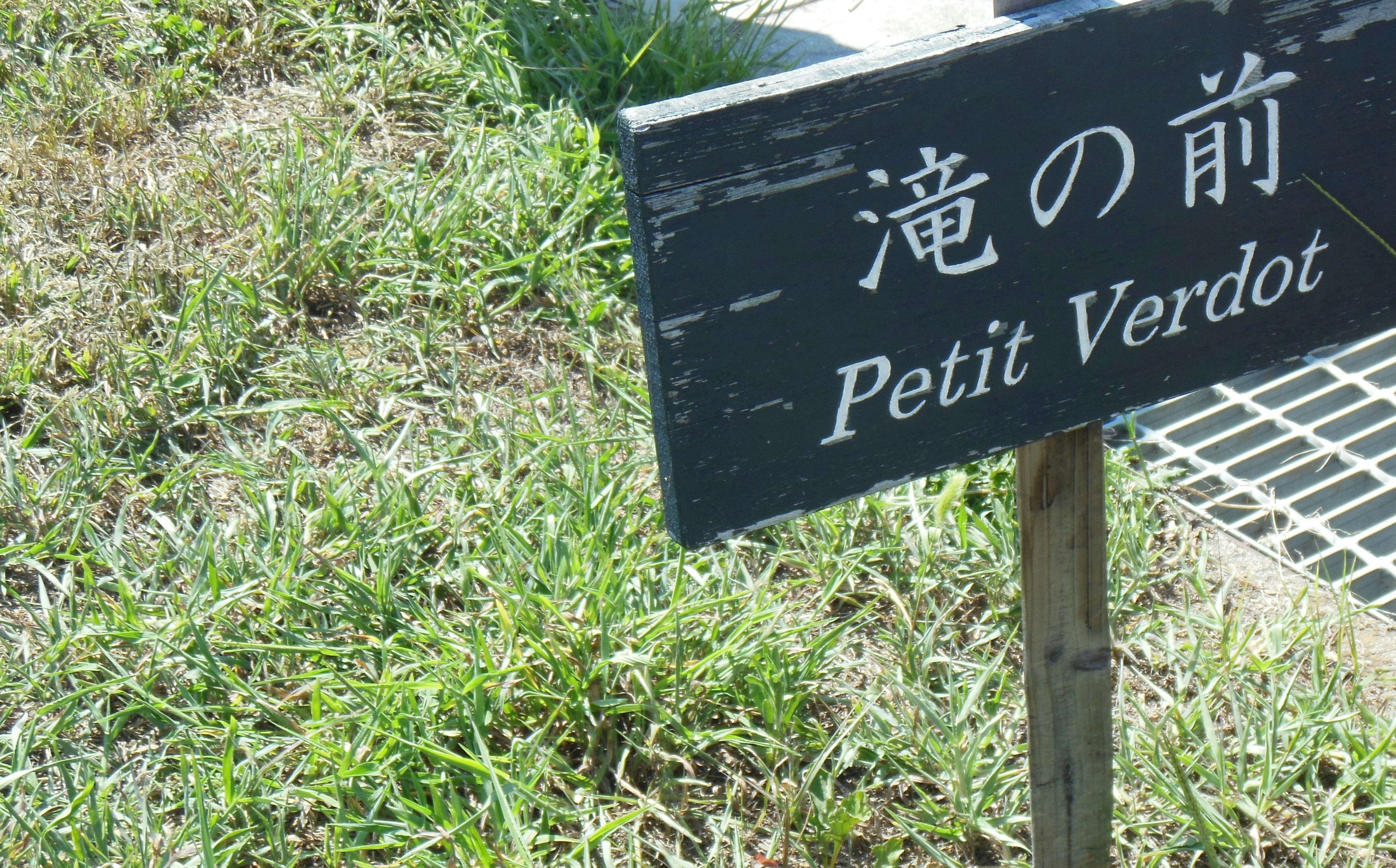 Panneau « Petit Verdor » et chemin bordé d’herbe