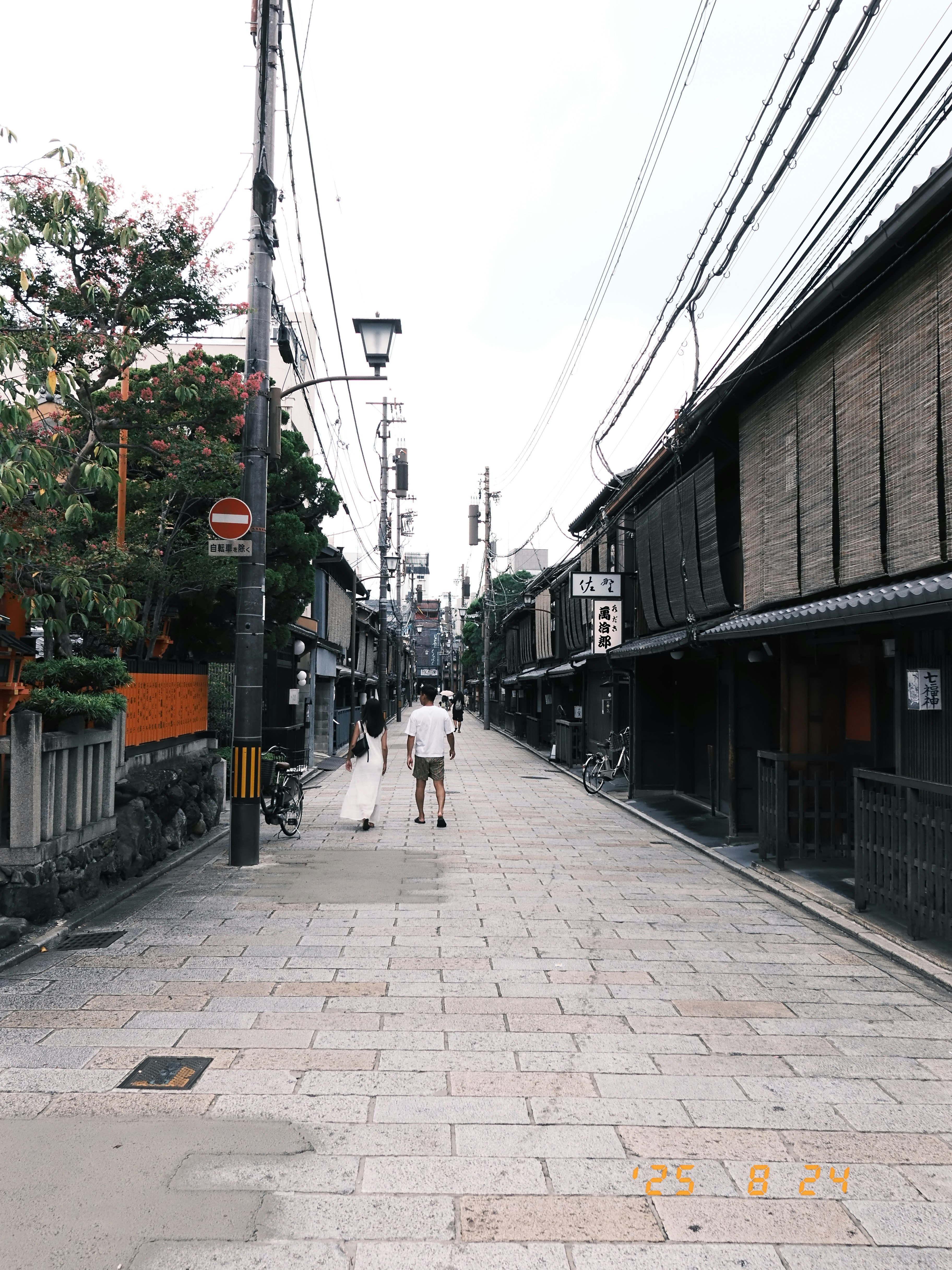 祇園の路地を歩く人々と店先の並ぶ街並み