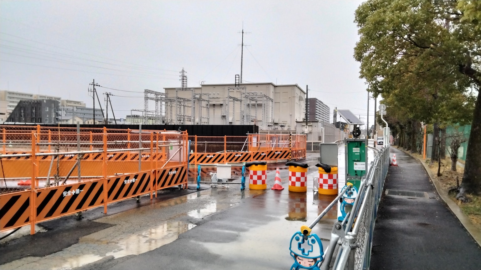 Scena di un cantiere con barriere arancioni e segnali di avvertimento su una strada