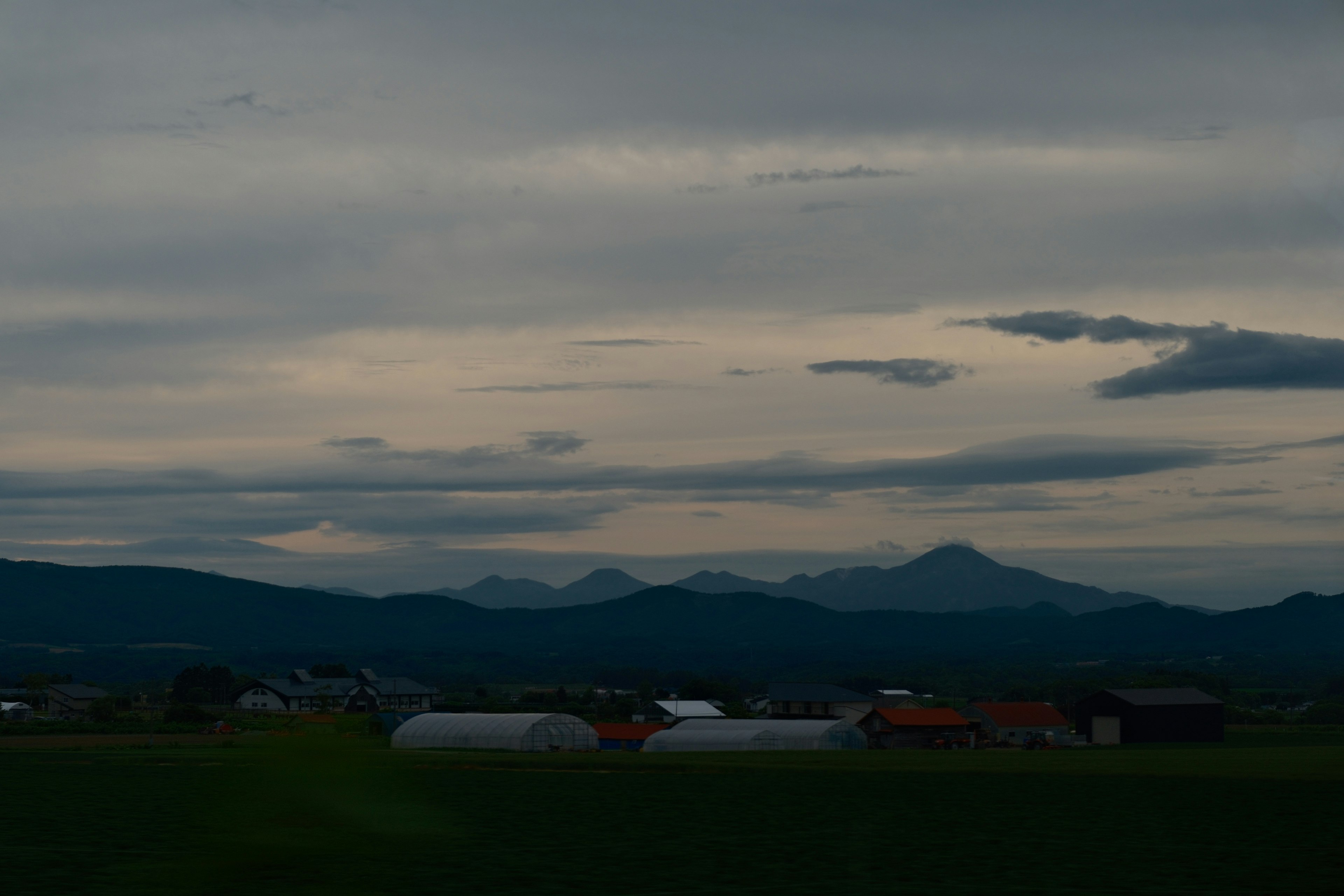 夕暮れの田園風景と遠くの山並み