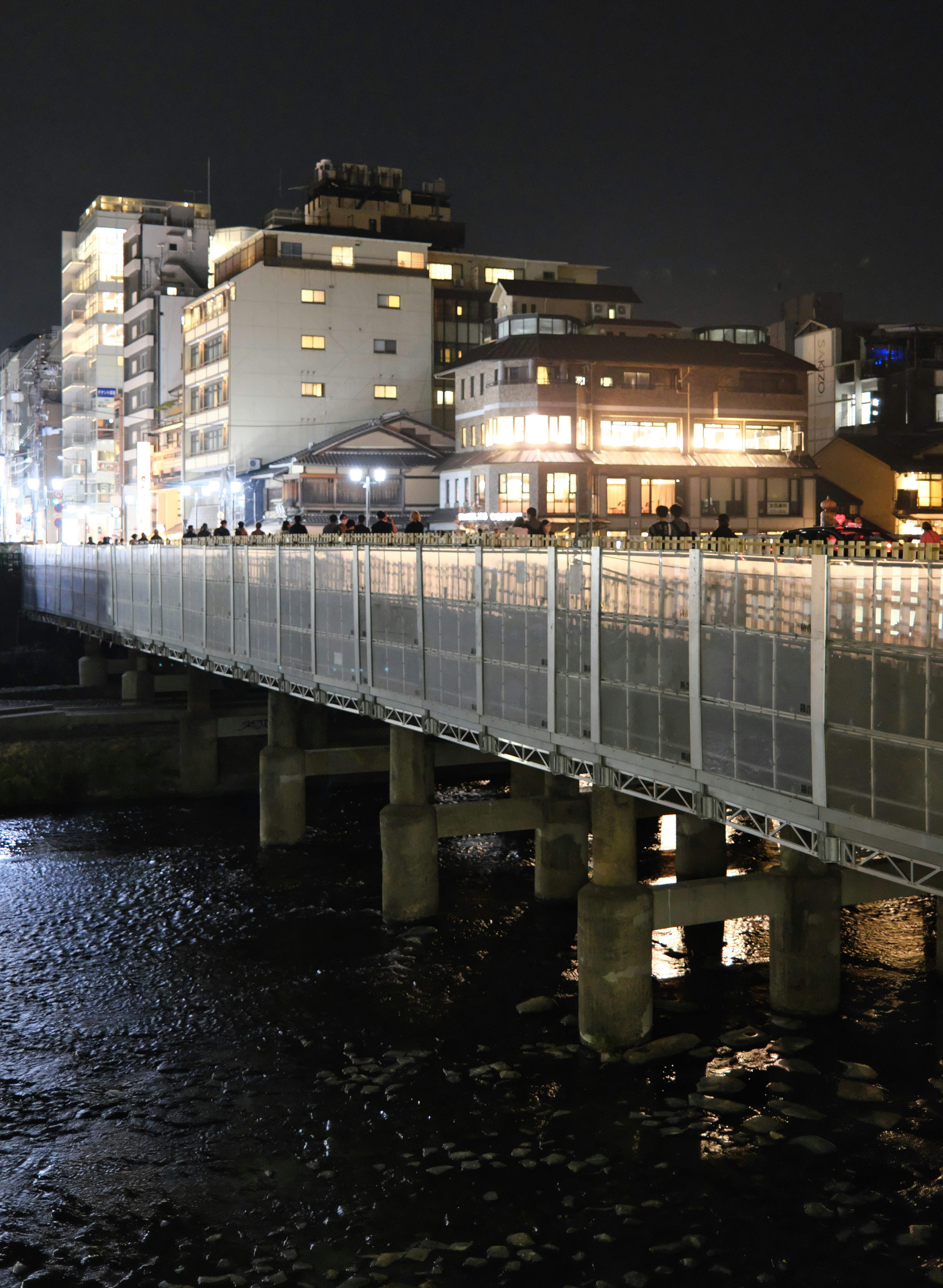 edifici lungo il fiume di notte e passeggiata illuminata