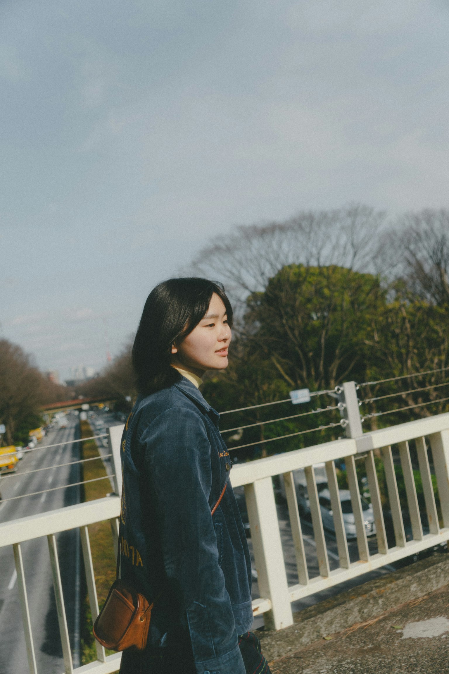 Une jeune femme souriante sur un pont avec un paysage pittoresque