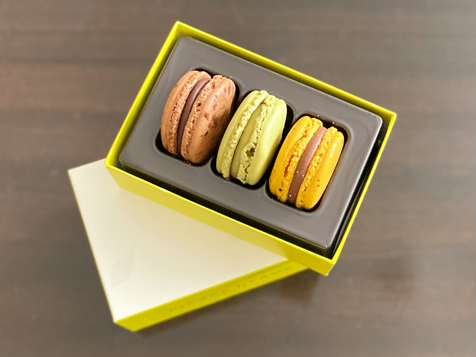 Macarons colorati in una scatola gialla