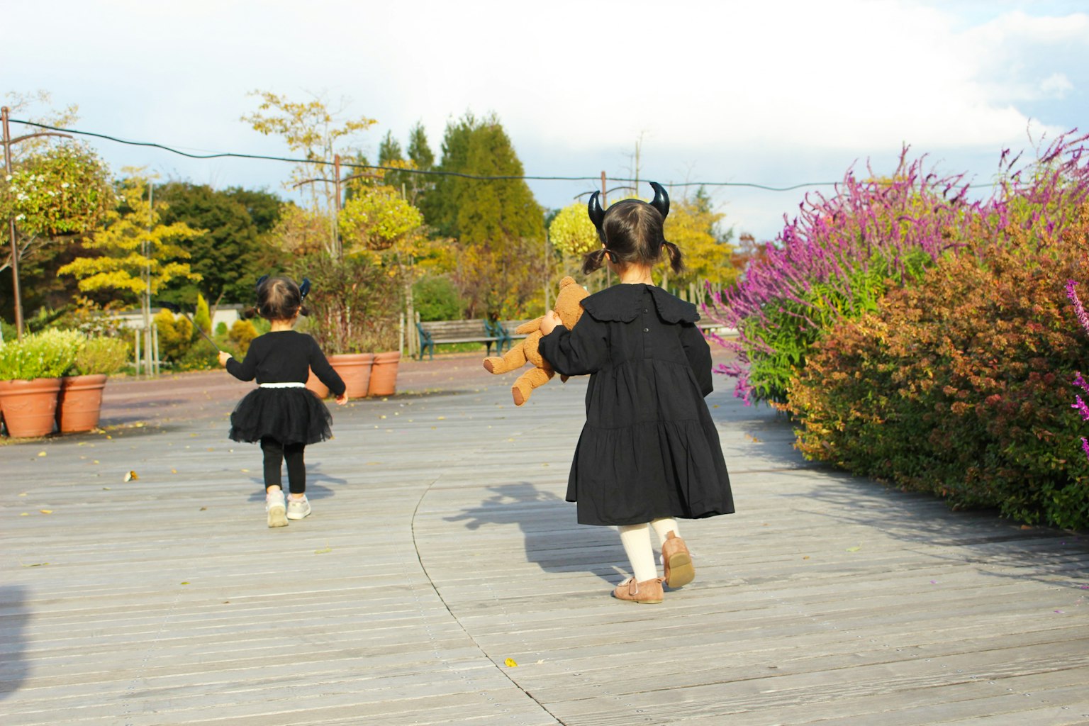 兩個穿著黑色裙子的孩子在公園裡走