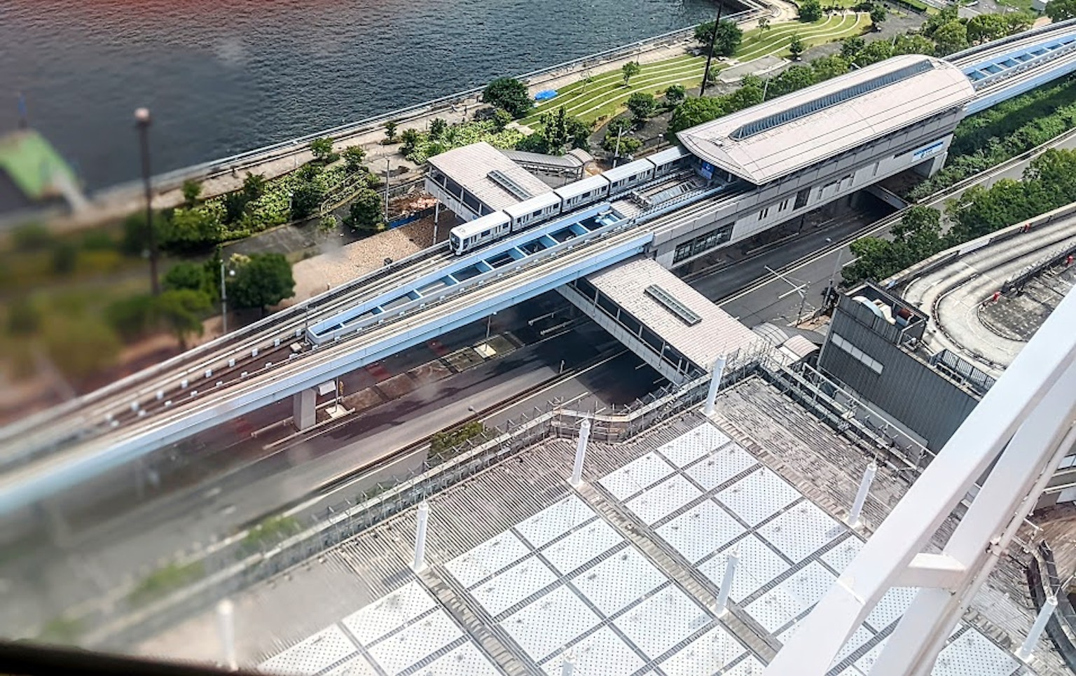 Pemandangan udara stasiun monorel dikelilingi pepohonan