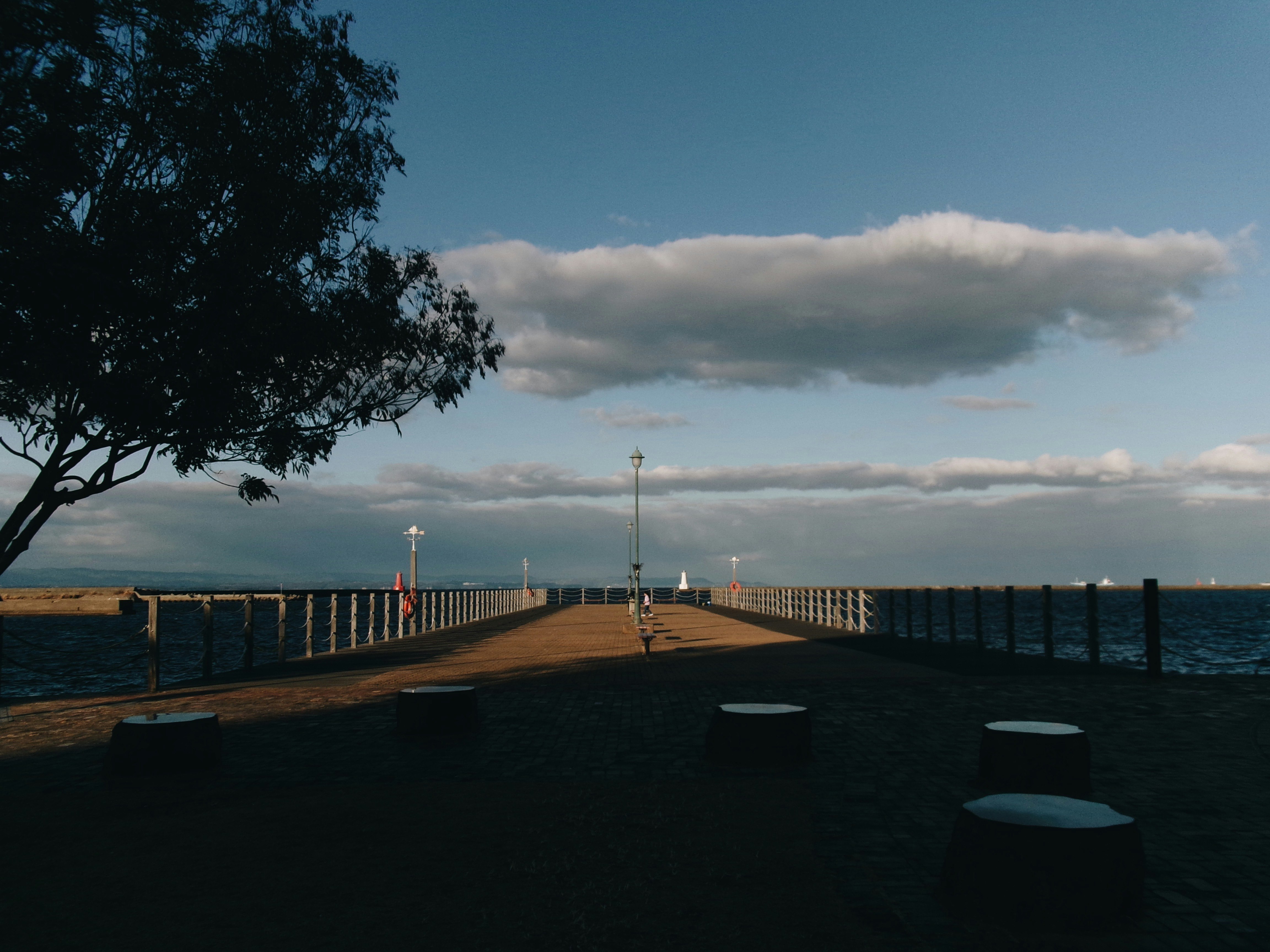 海沿いの遊歩道と雲の広がる空の風景