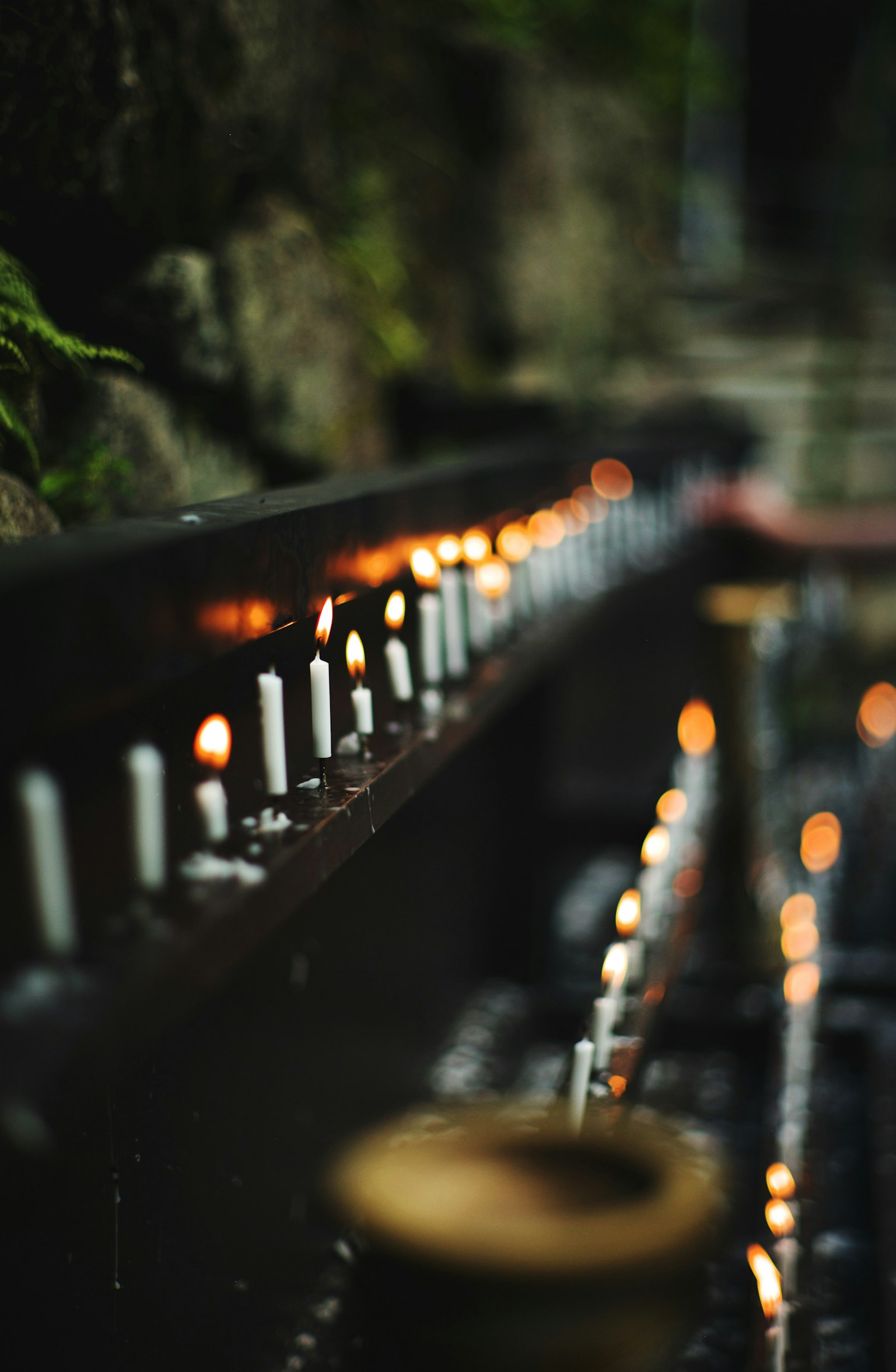 Suasana tenang dengan lilin yang disusun di atas permukaan gelap