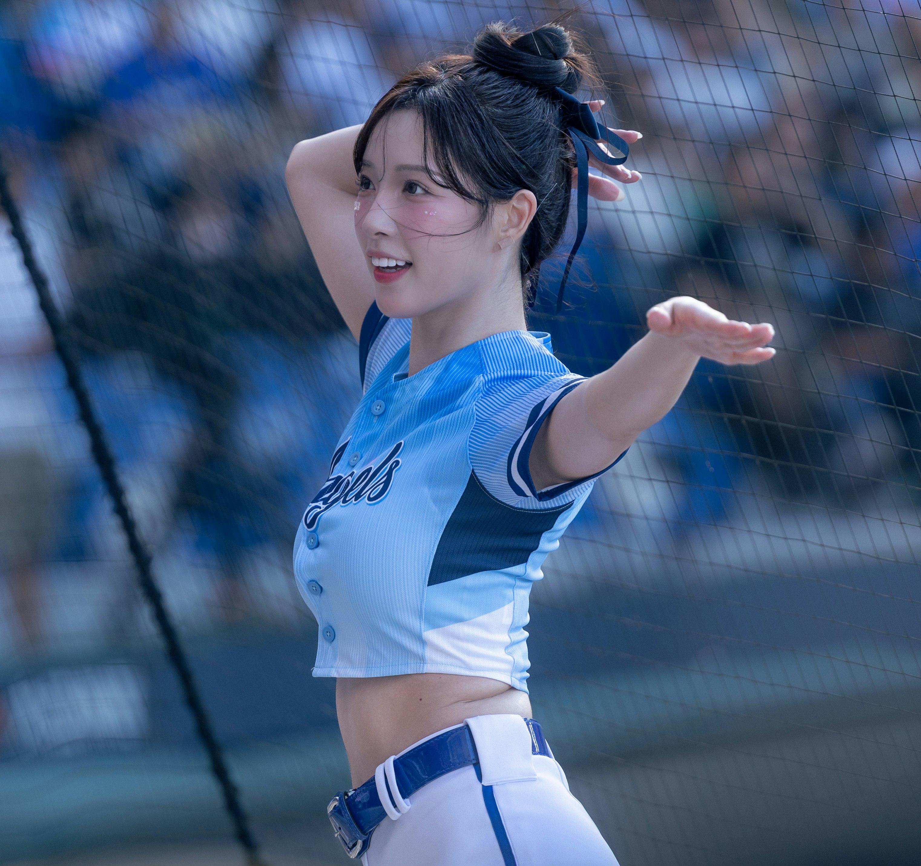 青いユニフォームの女性ランナーが手を広げて走る