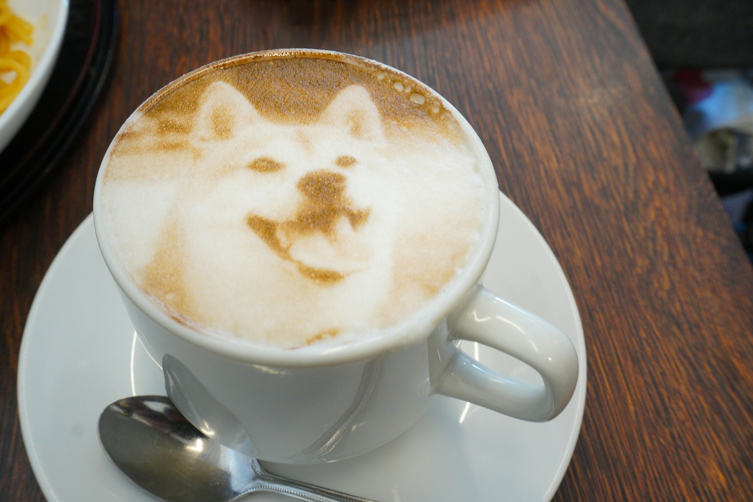 Tazza di caffè con arte del latte che rappresenta un cane sorridente
