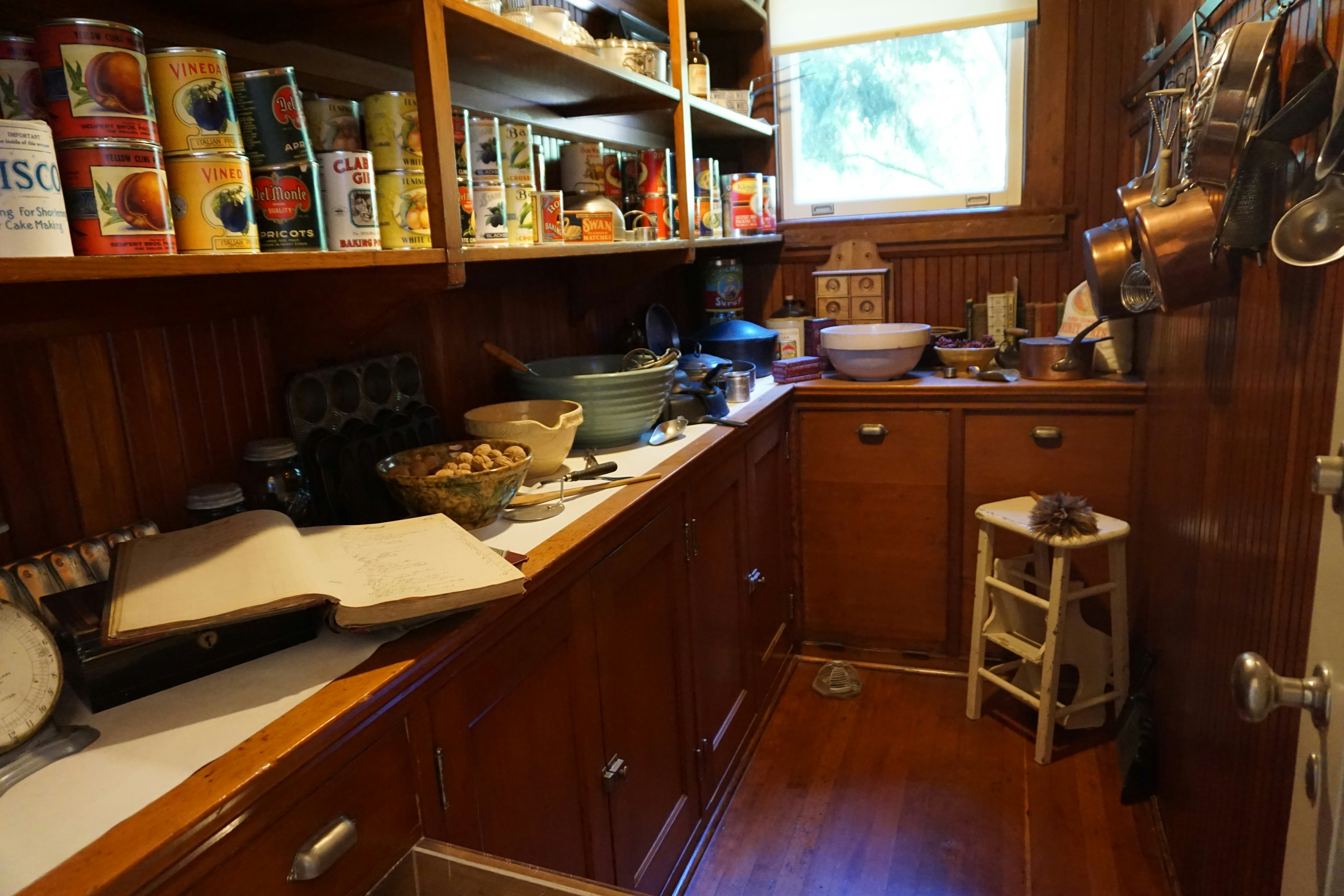 Small wooden kitchen with stacked dishes and jars of condiments