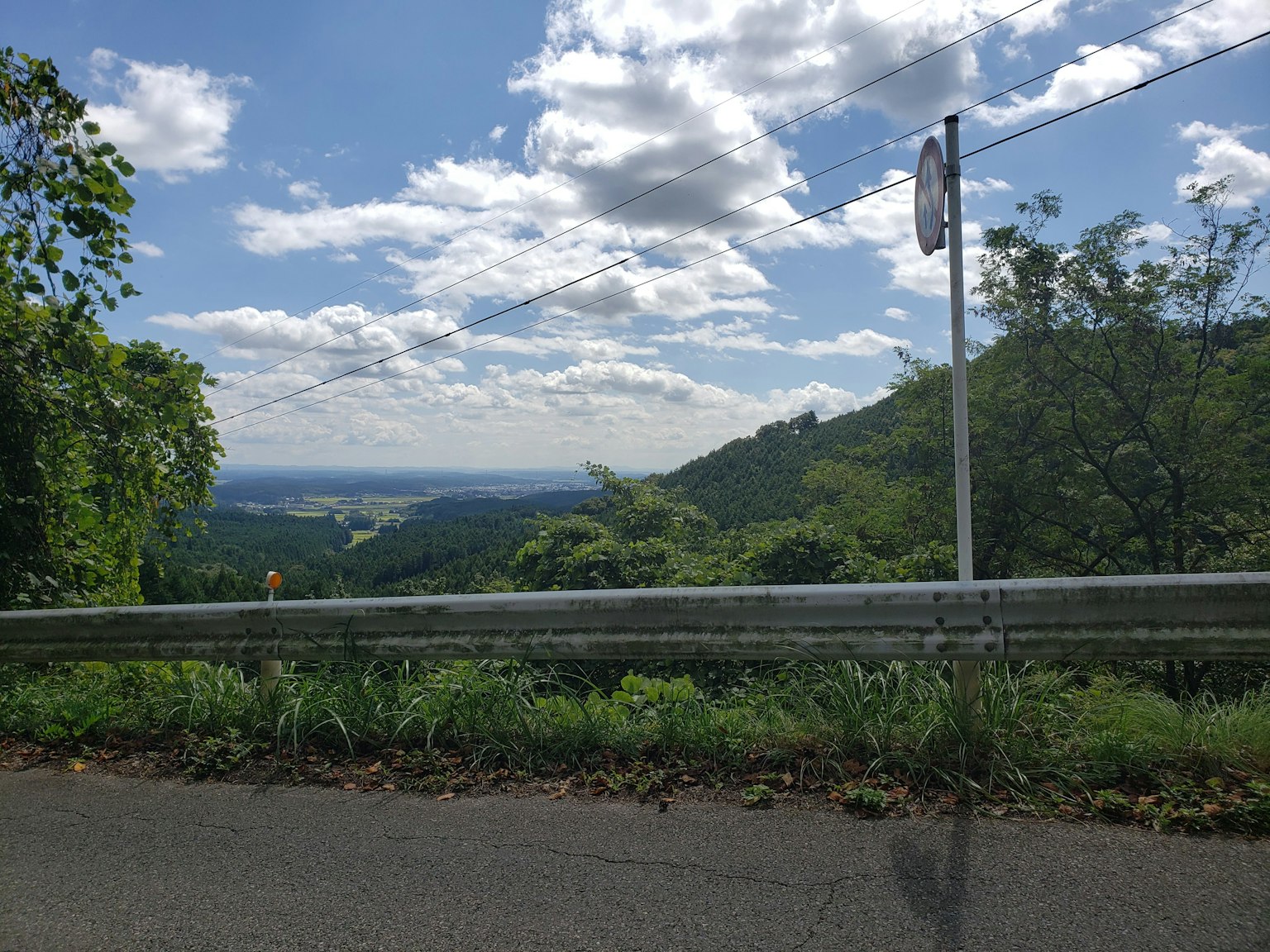 風景如畫的藍天和白雲郁郁蔥蔥的綠色山脈和道路護欄