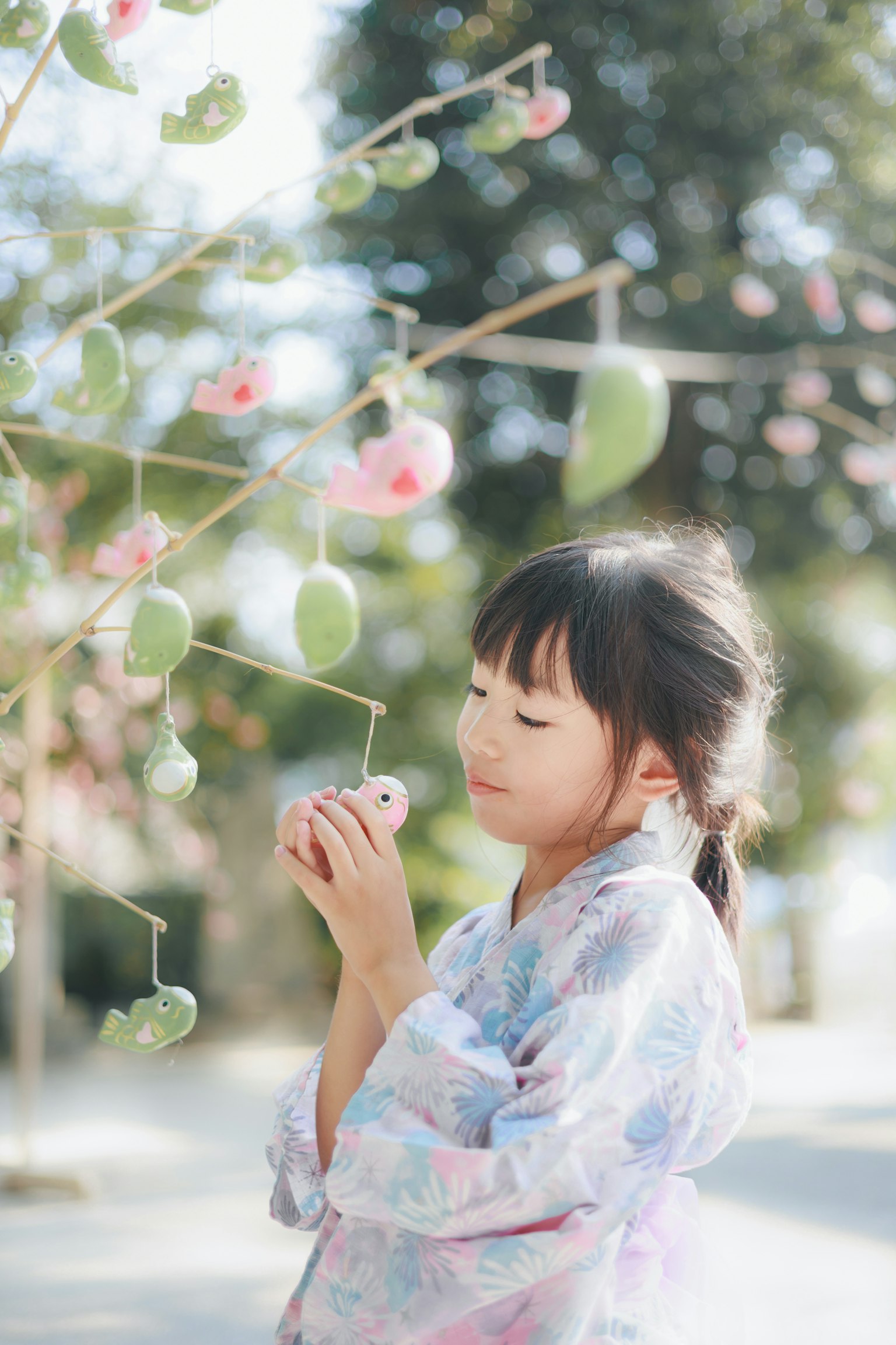 Una niña en kimono admirando flores de cerezo