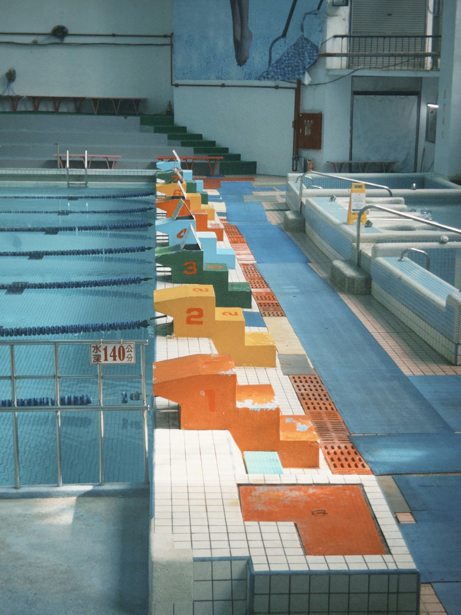 Installation de natation intérieure avec des blocs de départ colorés disposés le long de la piscine