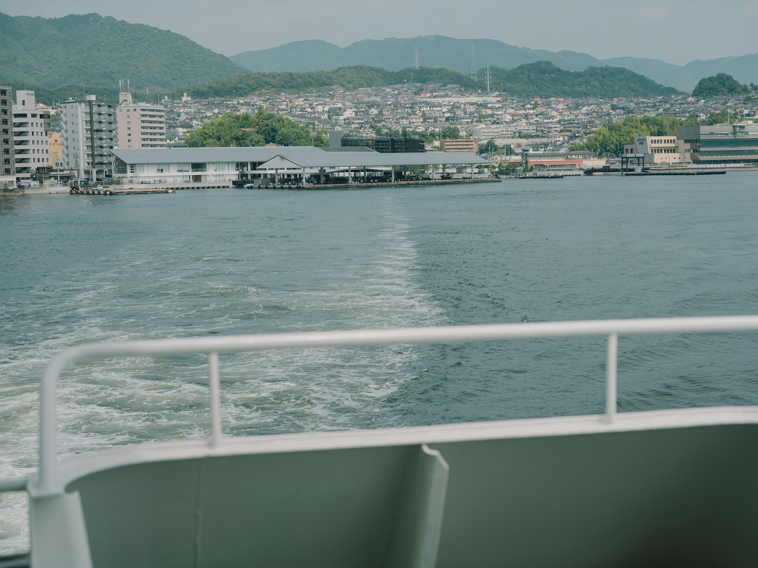 Vista desde un barco que muestra agua y montañas distantes