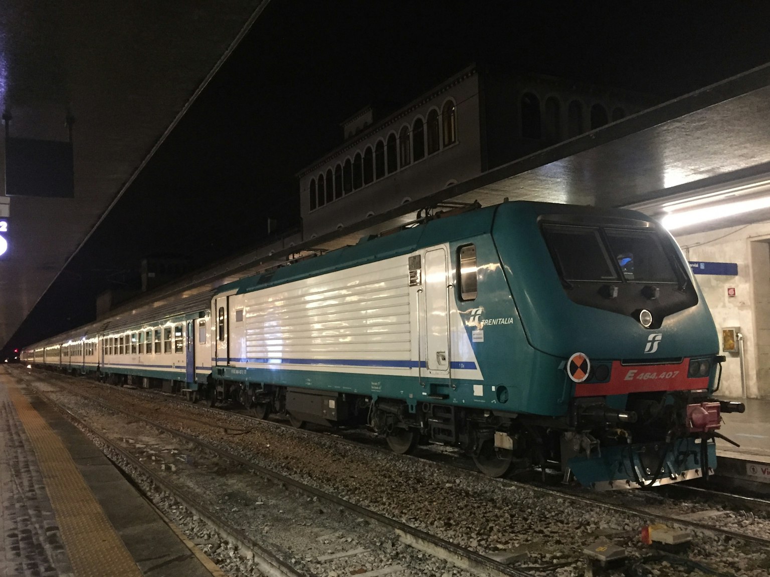 Treno blu fermo di notte in una stazione