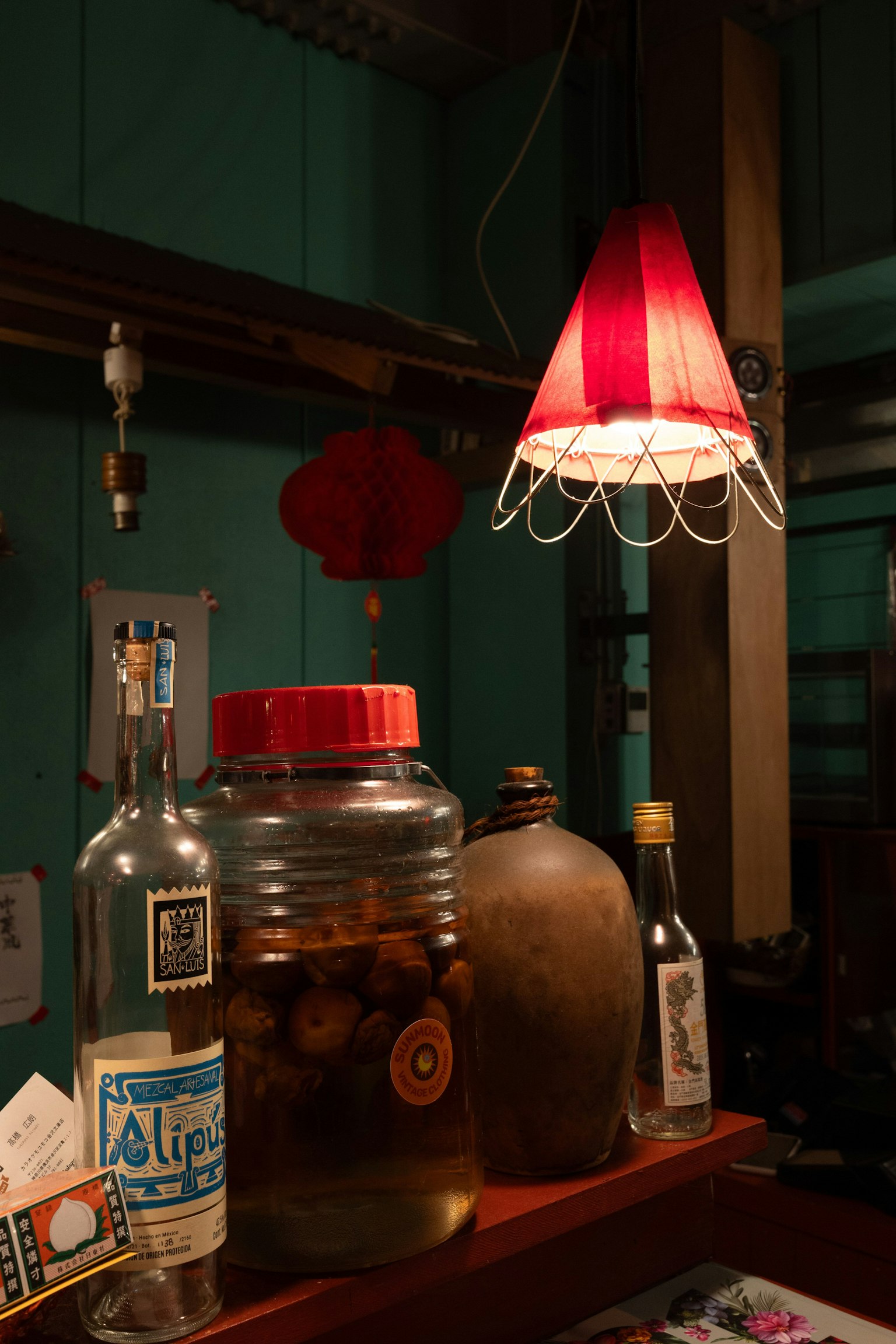 Vue intérieure d'un comptoir avec une lampe rouge et diverses bouteilles