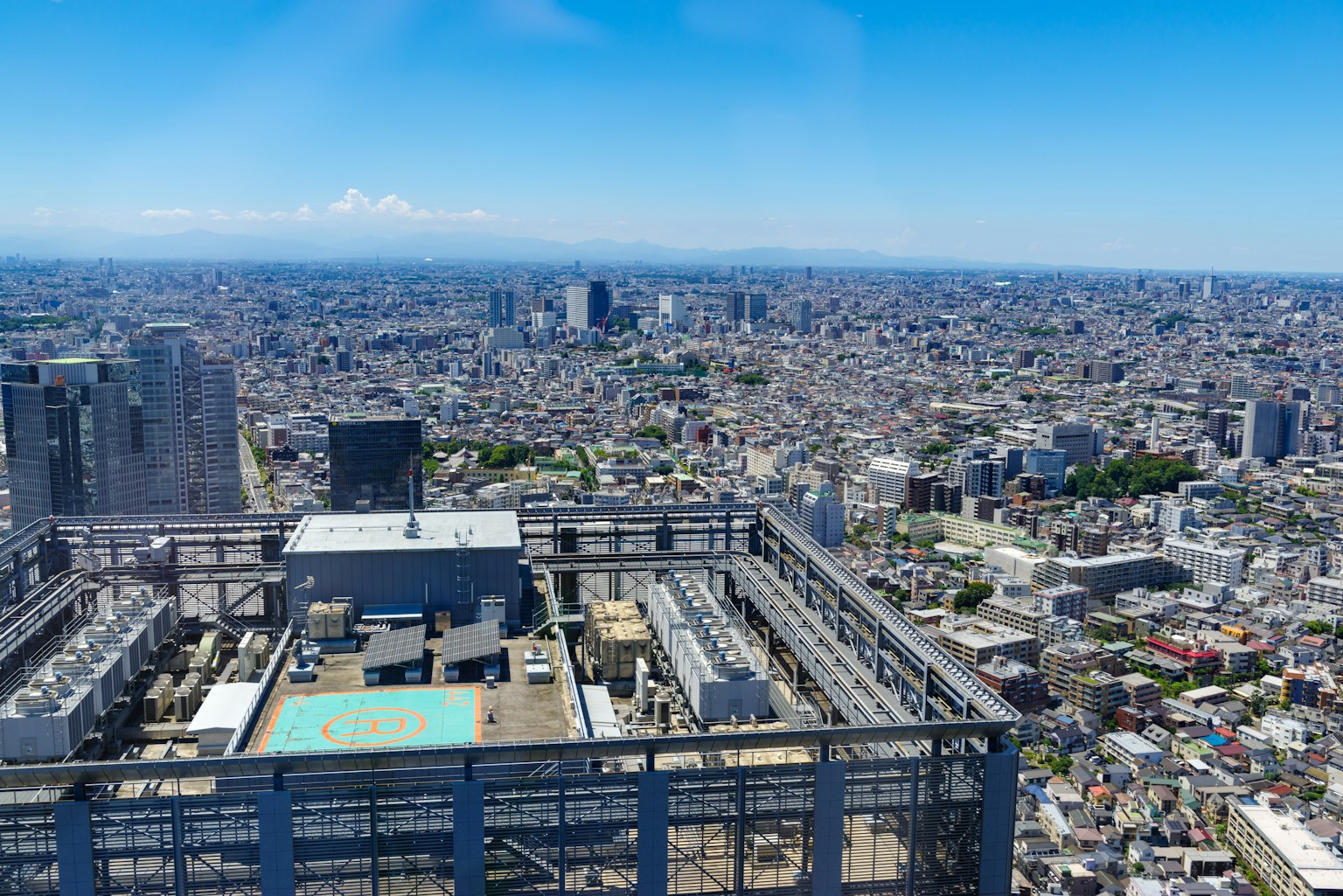 Vue depuis le toit d'un gratte-ciel à Tokyo paysage urbain vaste ciel bleu et montagnes au loin